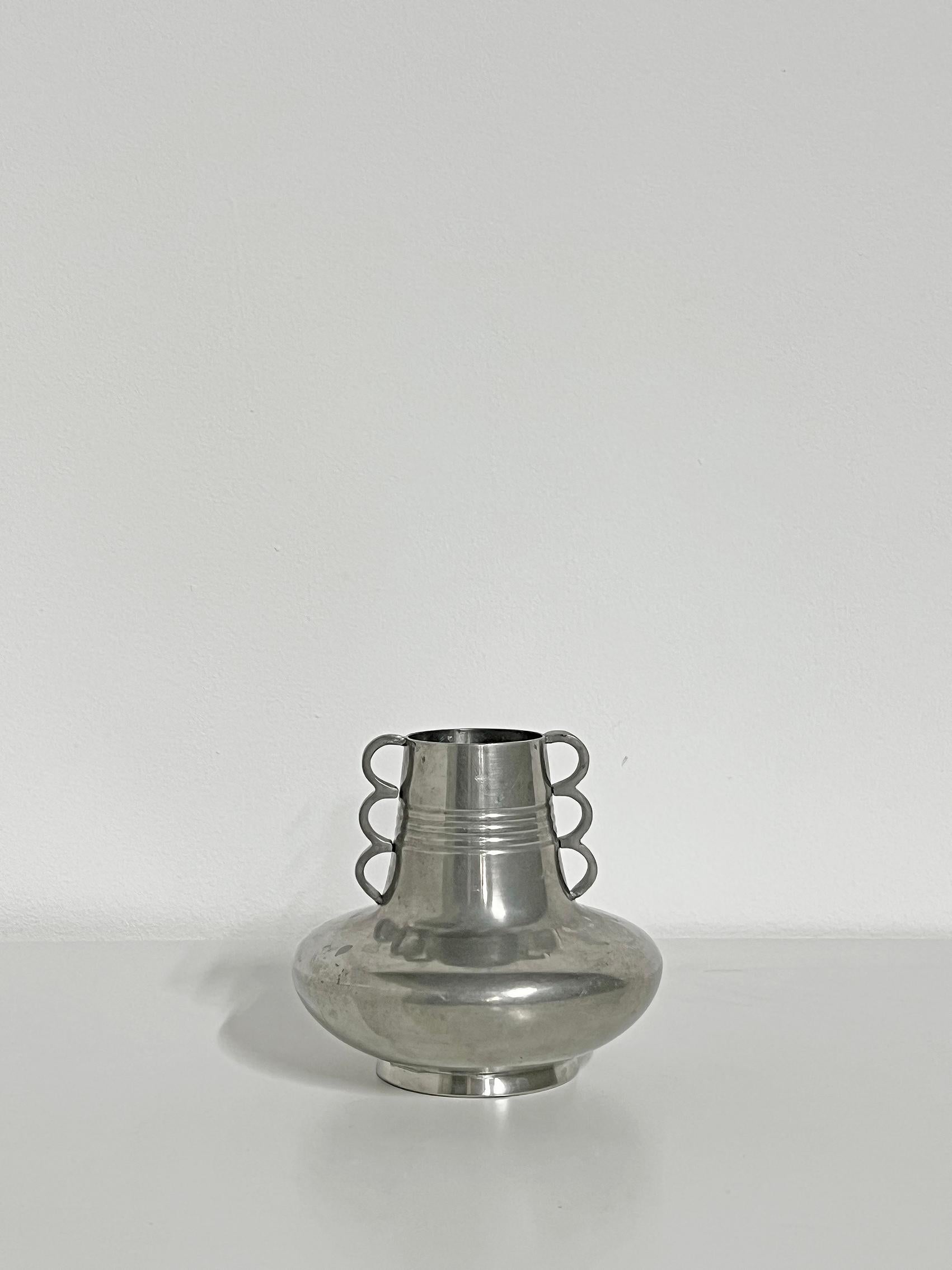 Kühle Vase aus Zinn von ADS, wahrscheinlich aus den 1930-40er Jahren. 
Abnutzung und Patina im Einklang mit Alter und Gebrauch. Kratzer, Schrammen, Flecken und eine Delle. 
Signiert mit Herstellerzeichen.