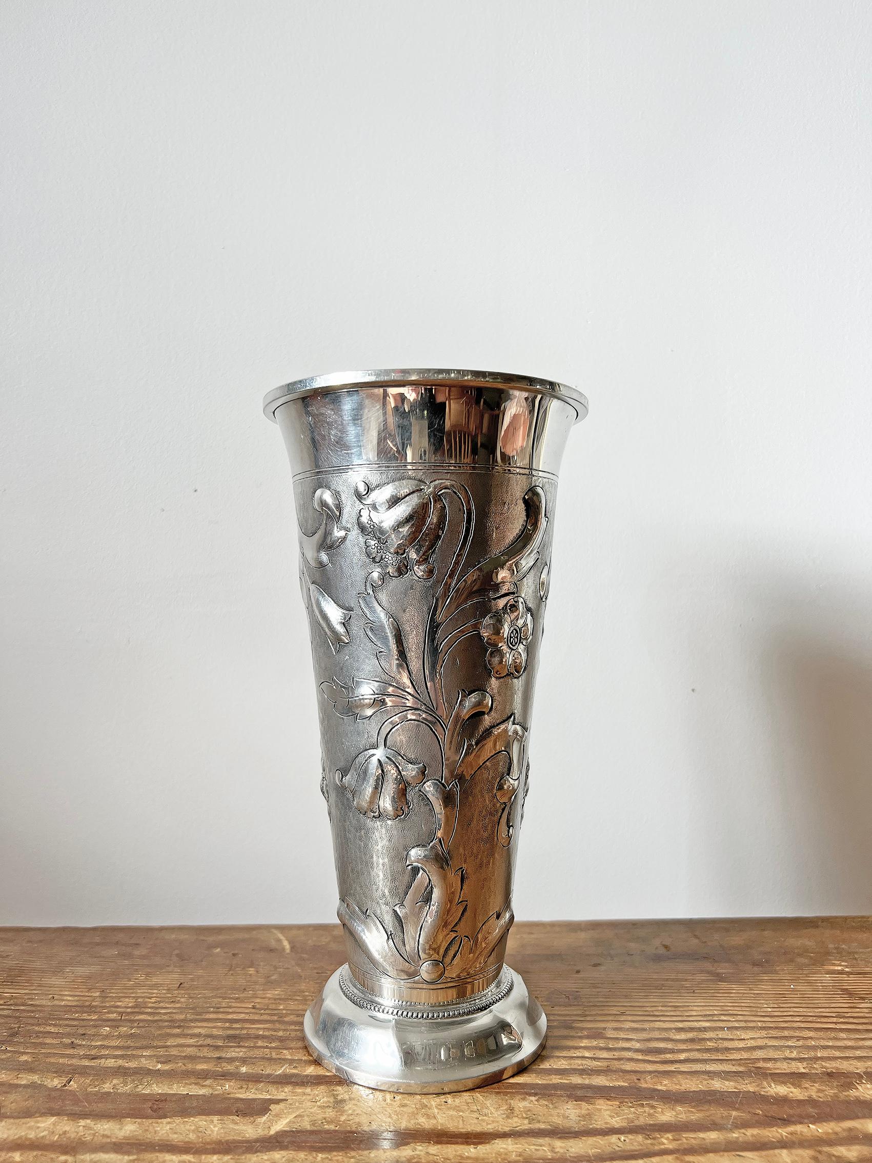 Beautiful vase in pewter by Tage Göthlin for Tesi - 1967. Decorated with flowers an leaves. 
Good vintage condition, wear consistent with age and use. Uneven base.

Please notice that there might be slight color difference between the picture and