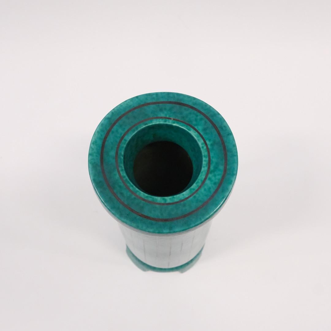 Vase ARGENTA de Wilhelm Kåge
H29,5 x Haut D12 x Bas D10cm
Ce vase ARGENTA au design élégant a été créé par Wilhelm Kåge pour Gustavsberg en Suède dans les années 1950.
La glaçure craquelée vert foncé, caractéristique de la série Argenta, est ornée