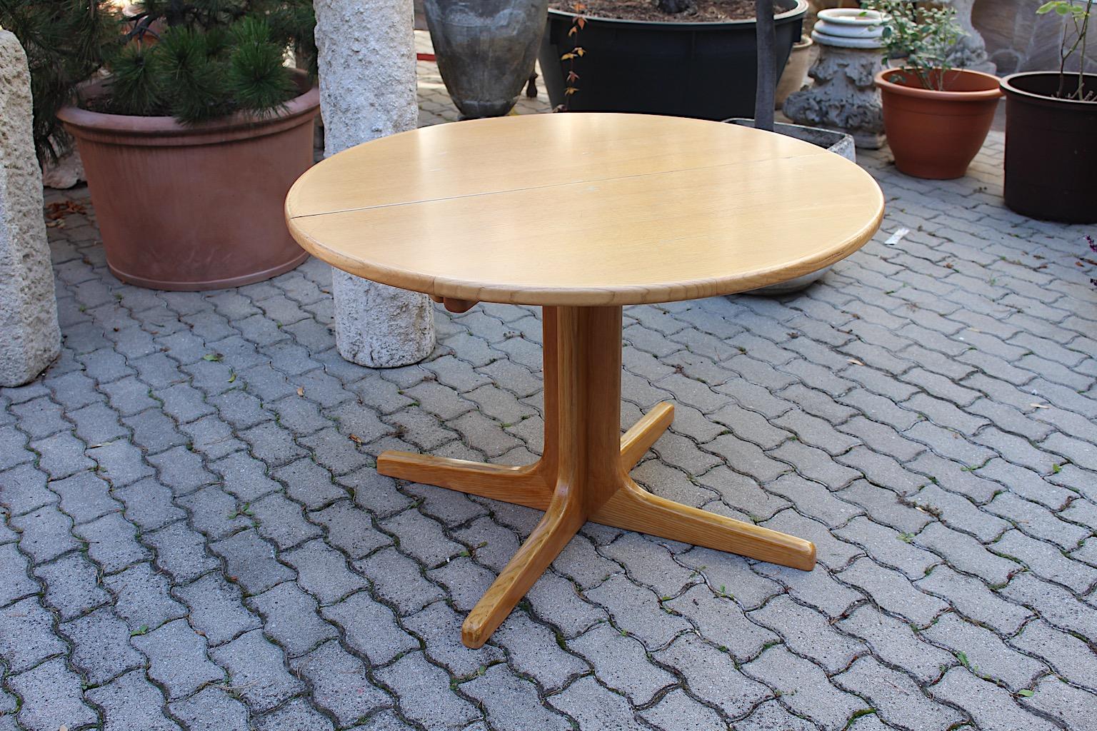 Scandinavian Modern vintage extendable dining table in round shape from ash by Niels Moeller, 1960s Denmark.
The round dining table shows two plates to enlarge the diameter from 110 cm to maximum length of 210 cm.
One plate has the measures 50 cm