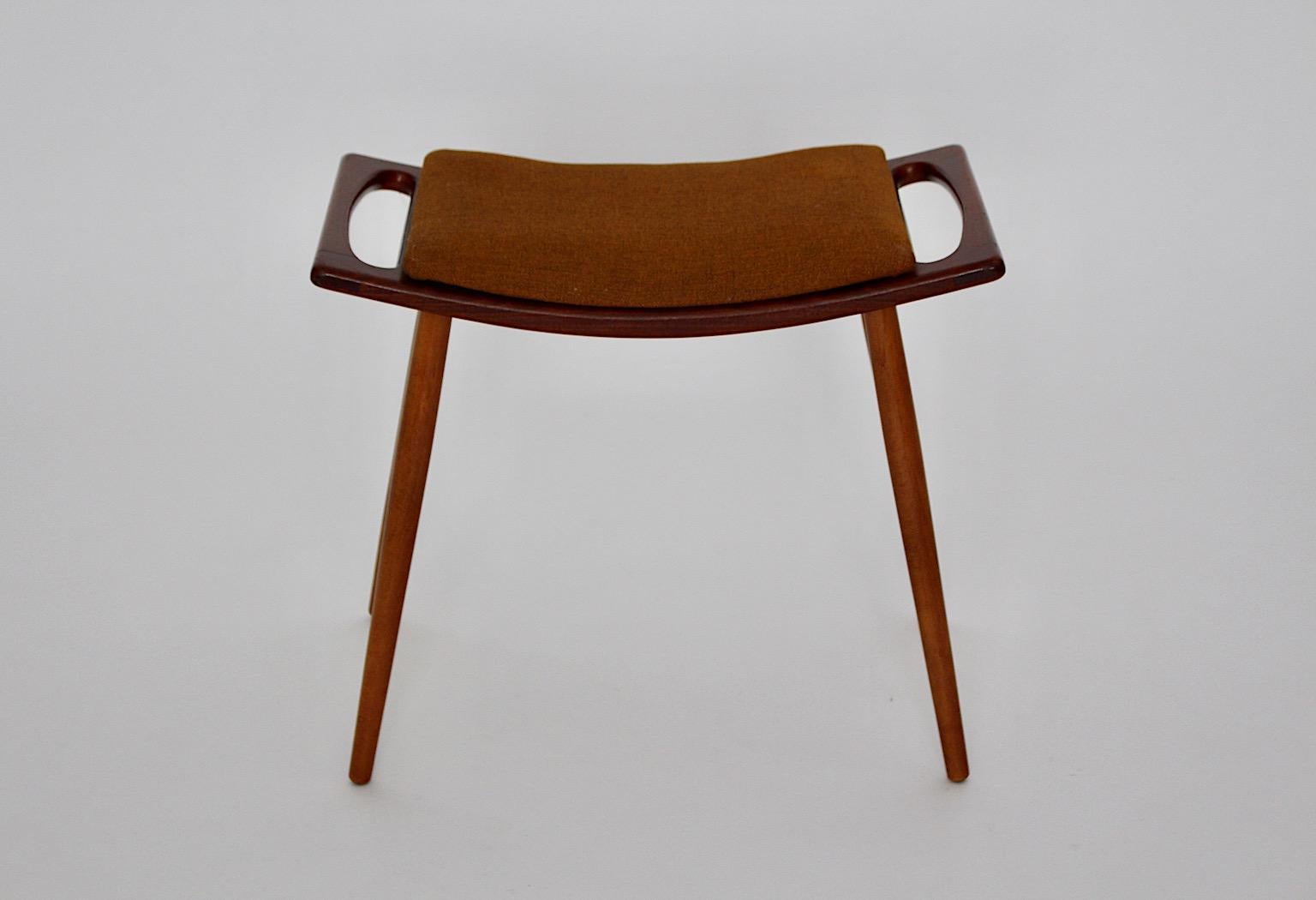 Taburete vintage moderno escandinavo de madera de teca de los años 60. El taburete muestra debajo una etiqueta de papel que da la información Model No. 85
Etiquetado debajo del asiento
El asiento está cubierto con el grueso tejido de lana naranja