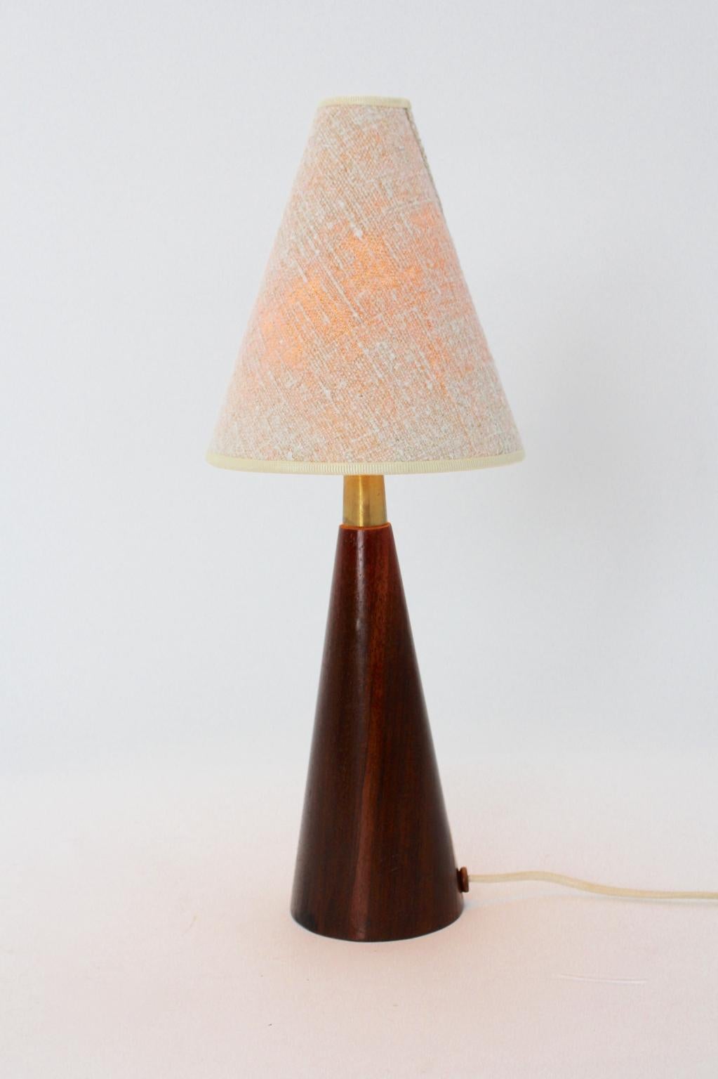 Lampe de table organique de style scandinave moderne et vintage, avec une base en teck de forme conique et un abat-jour en toile blanc cassé.
En outre, la lampe de table est équipée d'une douille E 27 et d'un interrupteur marche/arrêt.
La base en