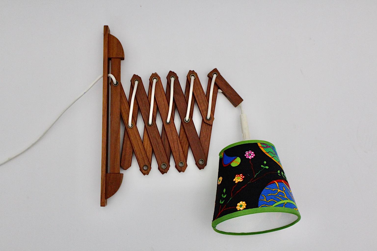 A amazing Scandinavian Modern vintage scissor lamp or wall light, which was made out of solid teakwood. The depth is adjustable from 31 cm to 93 cm.
Also the renewed lamp shade is covered with multicolored Josef Frank original design textile fabric