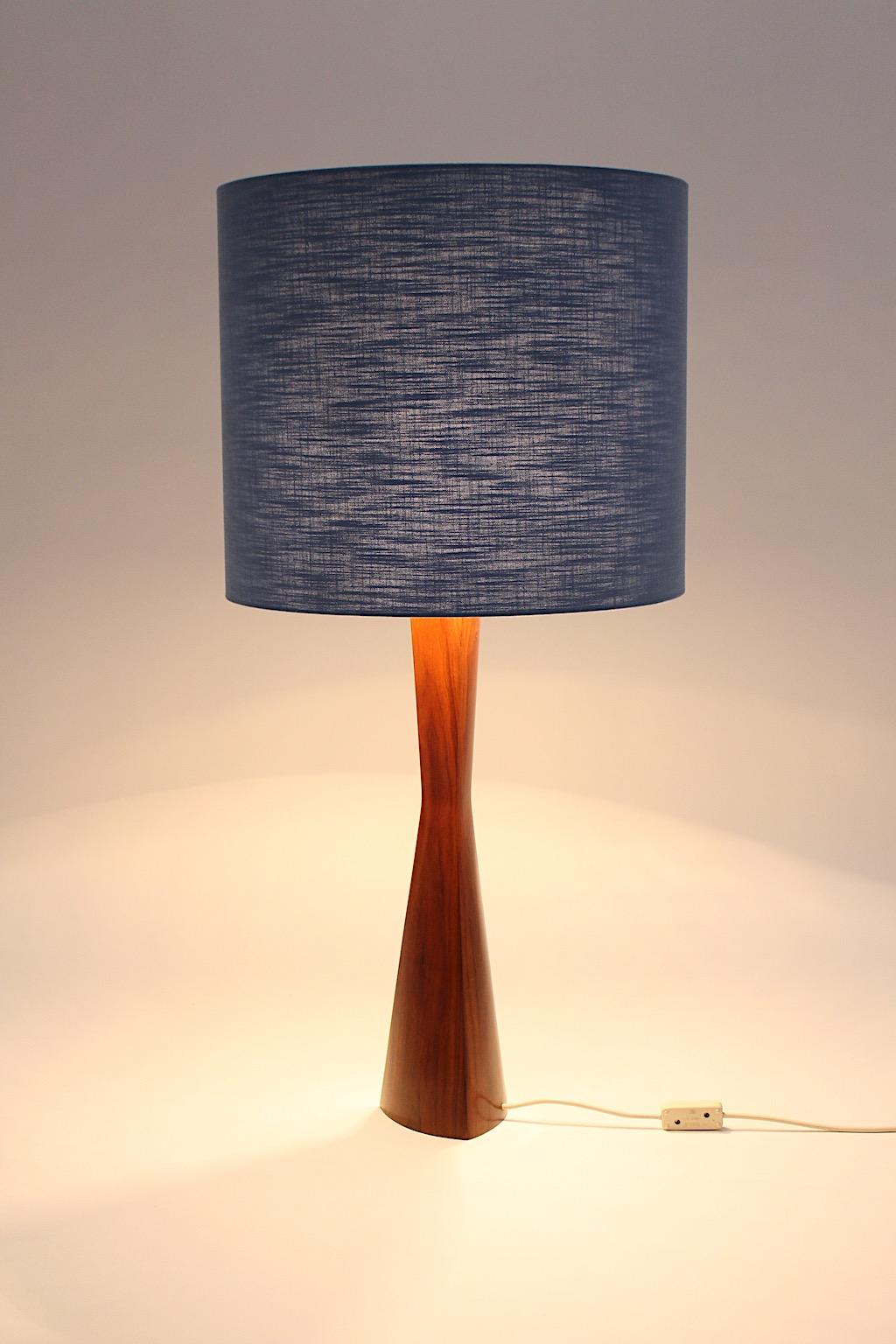 Scandinavian Modern vintage table lamp from teak with a renewed sky - blue textile fabric lamp shade.
The sculptural shape of the base from teak demonstrates beautiful warmth and luster.
The renewed lamp shade is covered with sky - blue textile
