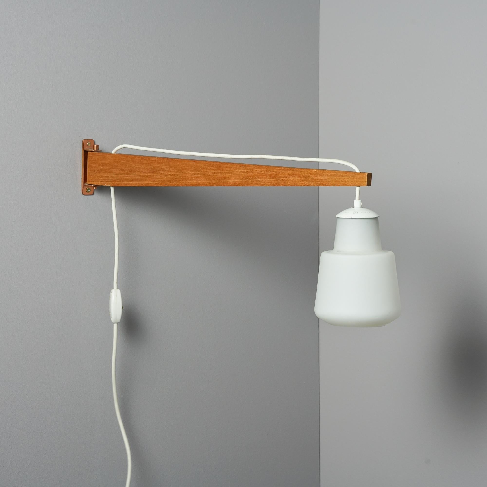 Scandinavian modern wall light by Itsu Finland from the 1960s. Teak frame, milk glass shade. Shade height adjustable. Manufactures stamp on the bottom. Good vintage condition, minor wear consistent with age and use.