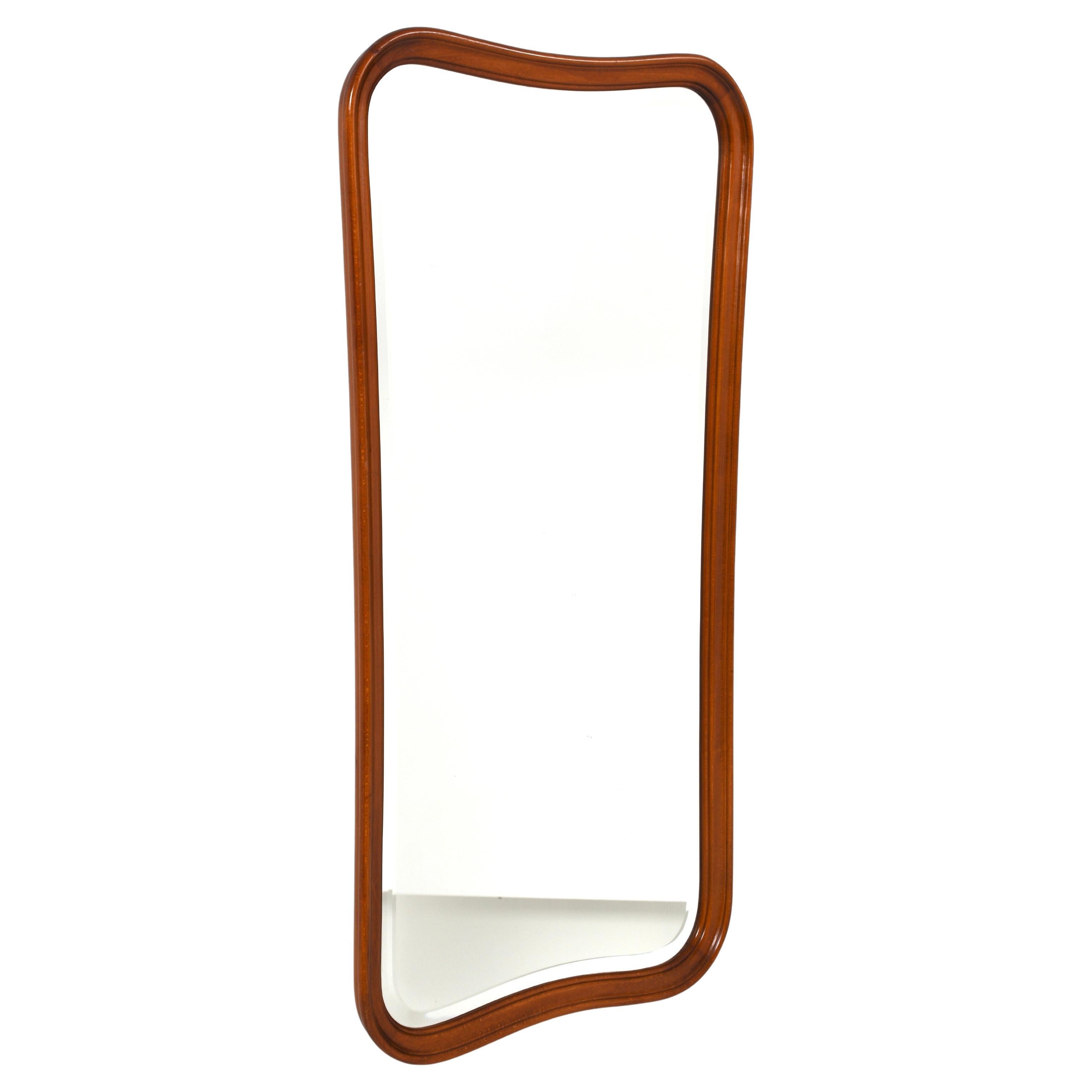 Elegante specchio da parete di metà secolo progettato e prodotto in Svezia da Glas & Trä Hovmantorp negli anni Quaranta. Questo specchio è caratterizzato da una scultorea cornice in legno massiccio con curve morbide e una bellissima finitura dai