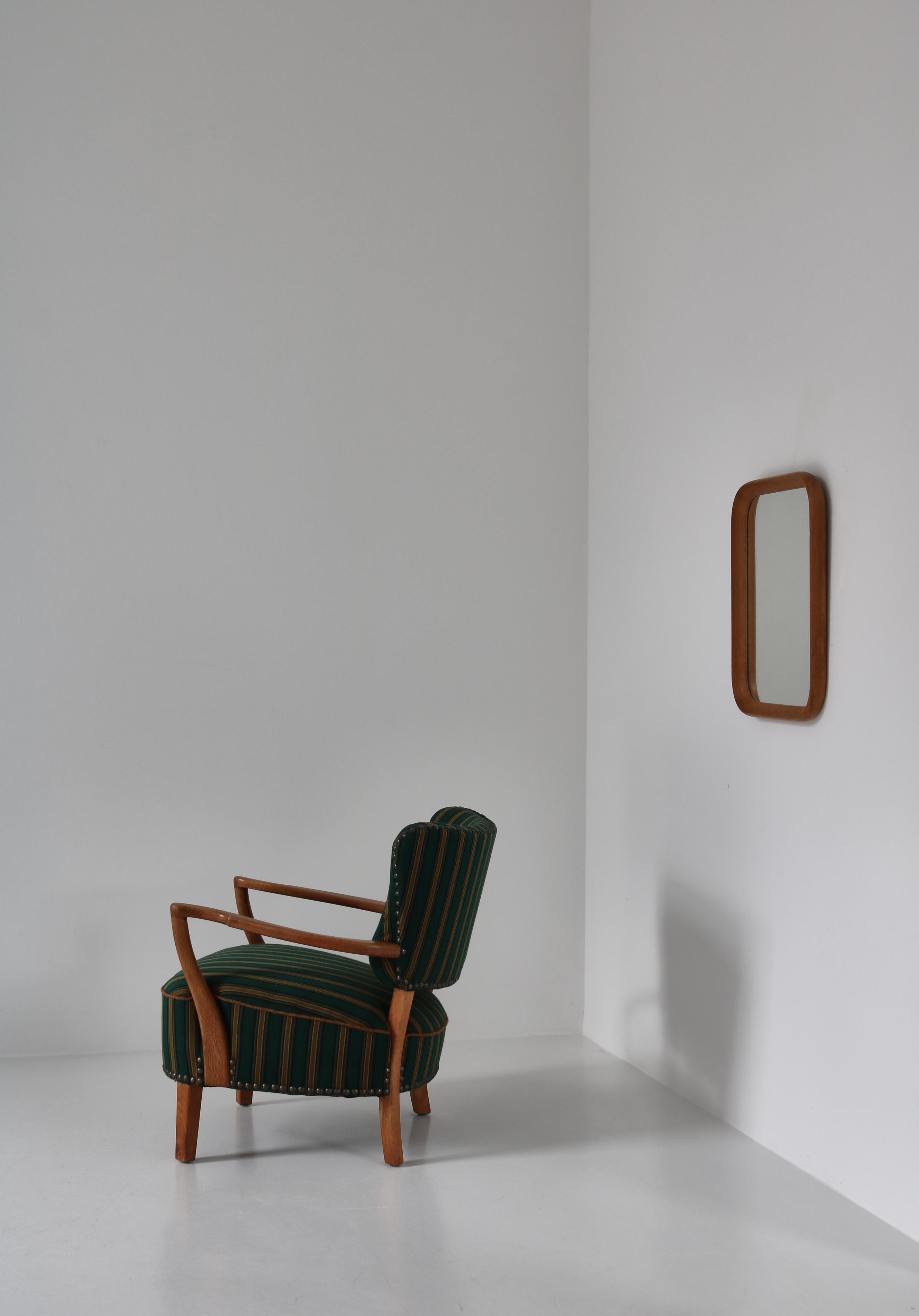 Wall mirror by a Danish cabinetmaker in the 1950s. The mirror is made of solid oakwood and is simple yet beautifully sculpted with brilliant joinery technique. In the style of Hans J. Wegner.