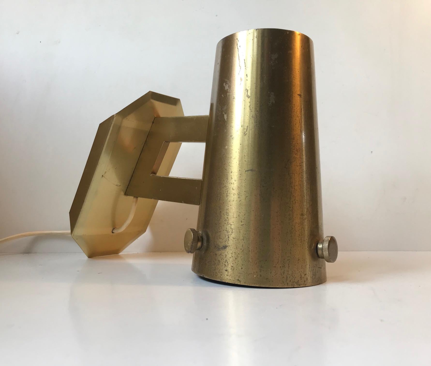 Fixed wall light in brass. Decorative engine turned bolts to the side. It hangs and lights up as depicted in photo number 4. It was made in Scandinavia during the 1960s. Probably by either Falkenberg or Bergboms.