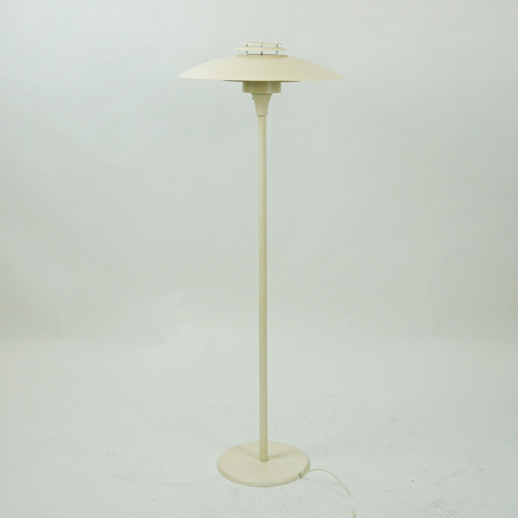 This charming Scandinavian floor lamp was produced by Lyfa Denmark in the 1960s. It features a Metal body and shade in a white lacquered finish.
The lamp provides 100 percent glare free light. Its design is based on the principle of a reflective