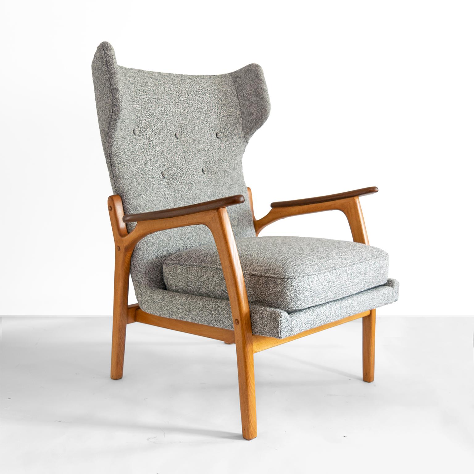 An elegant Scandinavian Modern wingback chair with a solid beech wood frame and detailed with teak armrest. Newly upholstered with a gray tweed like fabric. 

Measures: Height 40“ x Seat height 19“ x Width 27 “ x Depth 28“.
