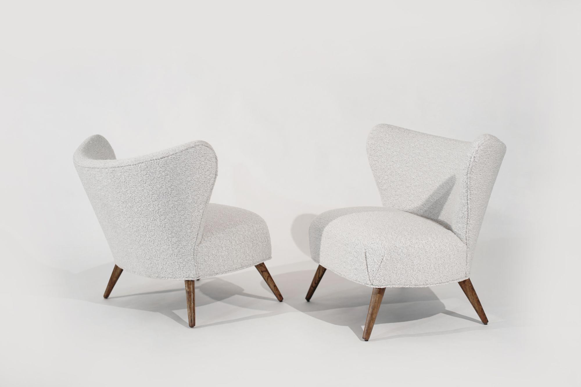 Experience timeless elegance with this set of Scandinavian Modern Wingback Lounges from Denmark, circa 1950-1959. Meticulously restored, these lounges feature fully restored teak legs and are luxuriously reupholstered in off-white bouclé. The sleek