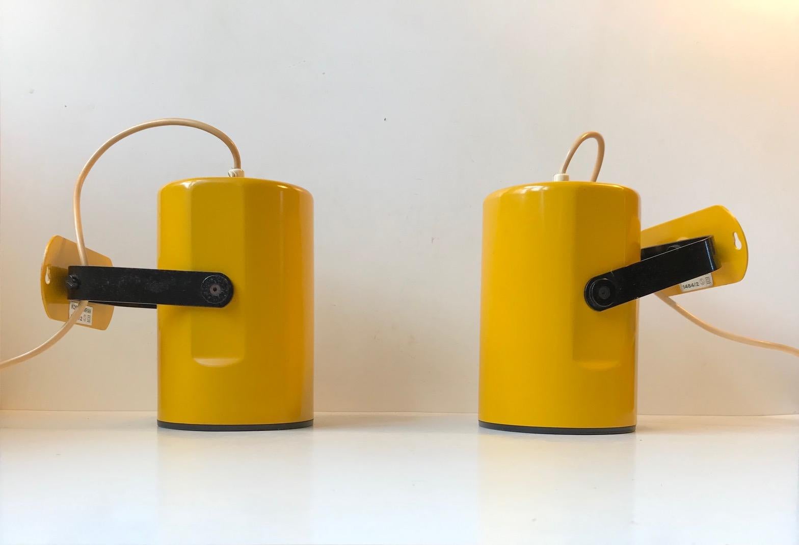 A pair of bright yellow wall lamp / bedside, hallway, living room etc. Fully adjustable up, down and side to side. Simple construction almost Industrial in appearance. These lights were manufactured by Kosta Lampan in Sweden during the 1970s and