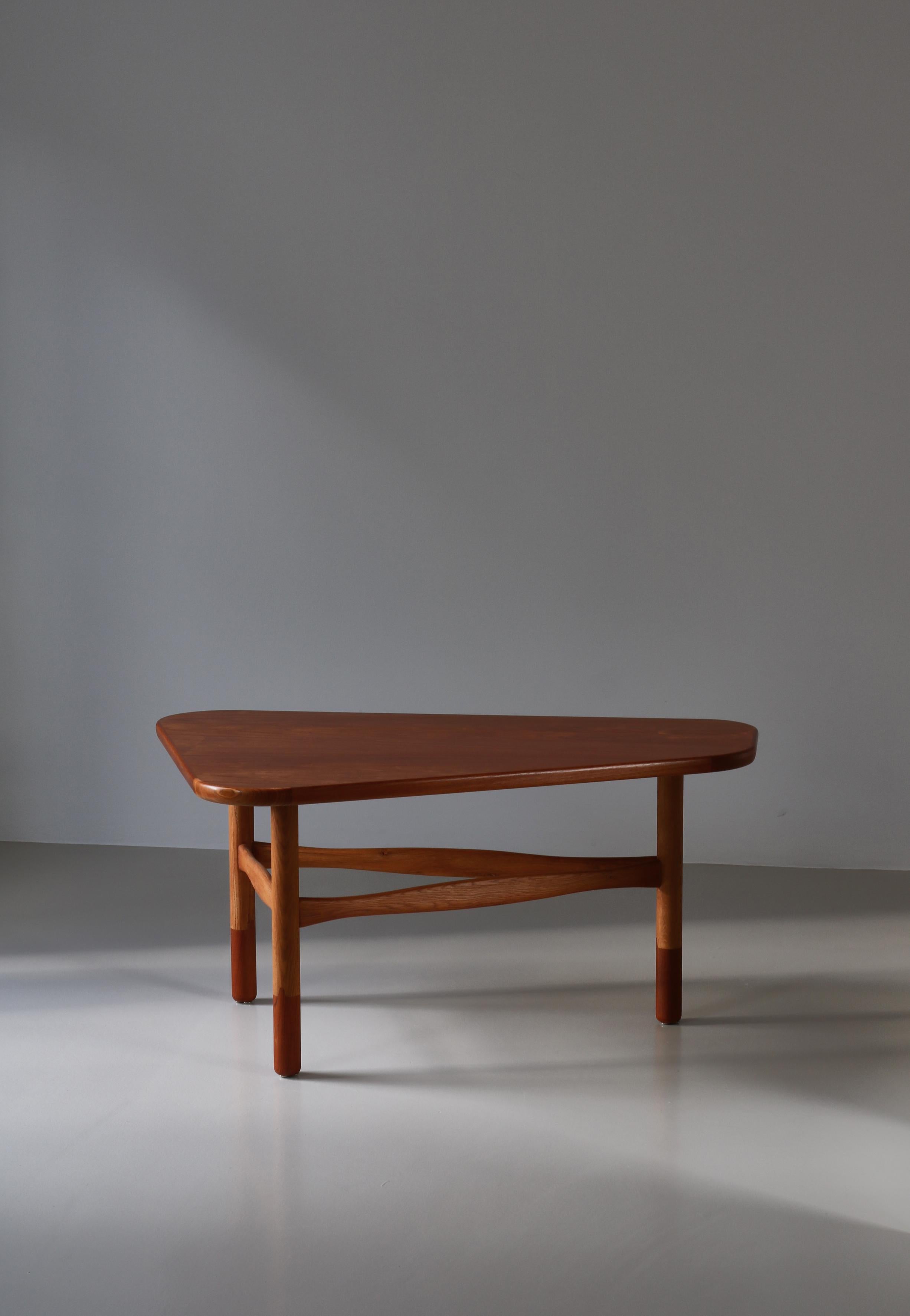 Seltener klobiger Couchtisch, entworfen von Yngve Ekström in den 1950er Jahren und hergestellt von Westbergs Möbler in Schweden. Dieser wunderbare Tisch hat eine sanft gerundete dreieckige Teakholzplatte, die auf drei Beinen aus massiver Eiche ruht,