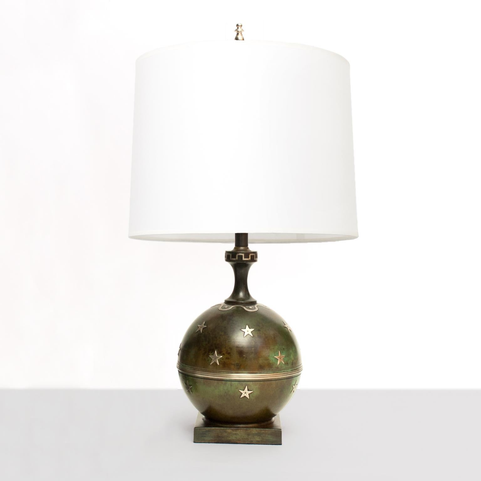 A Scandinavian modern spherical patinated bronze lamp on a rectangular plinth decorated with small stars in silver. Model is 