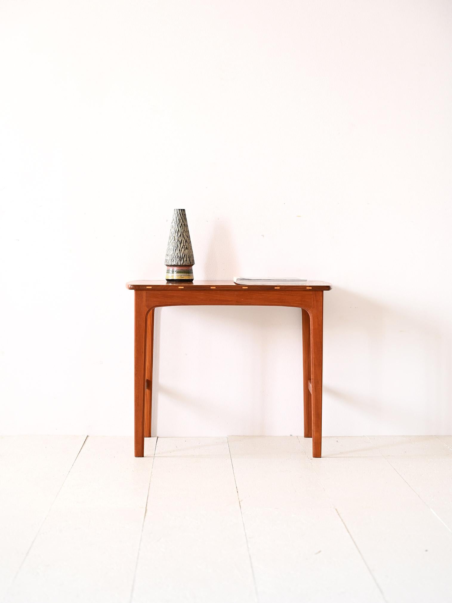 1960s teak table.

An elegant piece of furniture with timeless beauty. The essential lines and careful details make it a coffee table suitable for embellishing any room with simplicity.
Its peculiarity lies in the presence of the light wood inlays