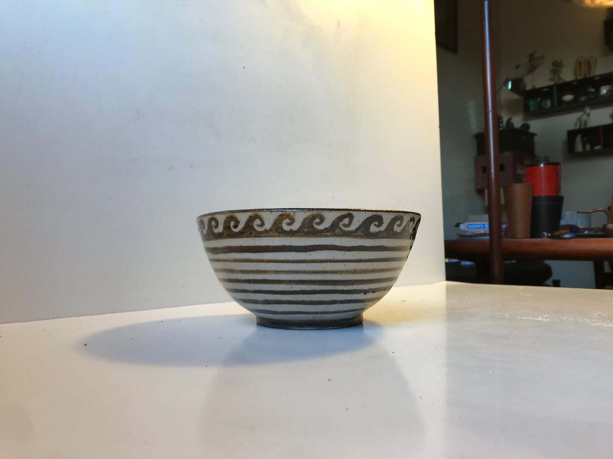 Ceramic bowl decorated with waves and interior with rings within rings. Its a fully hand glazed/decorated piece unique by the danish ceramist Henriette Duckert. It dates from her Copenhagen studio days and its was executed between 1971-1979. Its