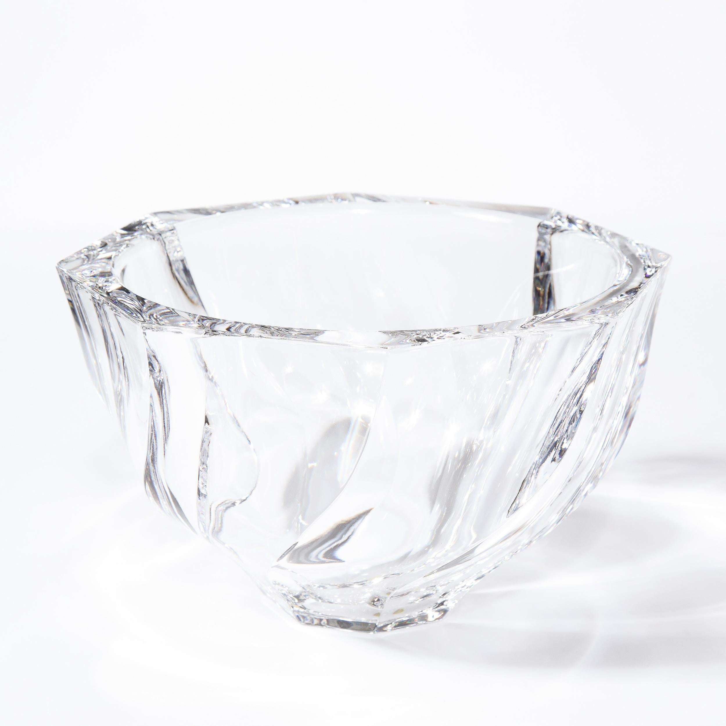 This refined modernist bowl was realized in Sweden by the renowned maker Orrefors. It features an octagonal mouth and undulating curved faceted sides in translucent glass. This piece offers the significant heft that one expects of a luxury object of
