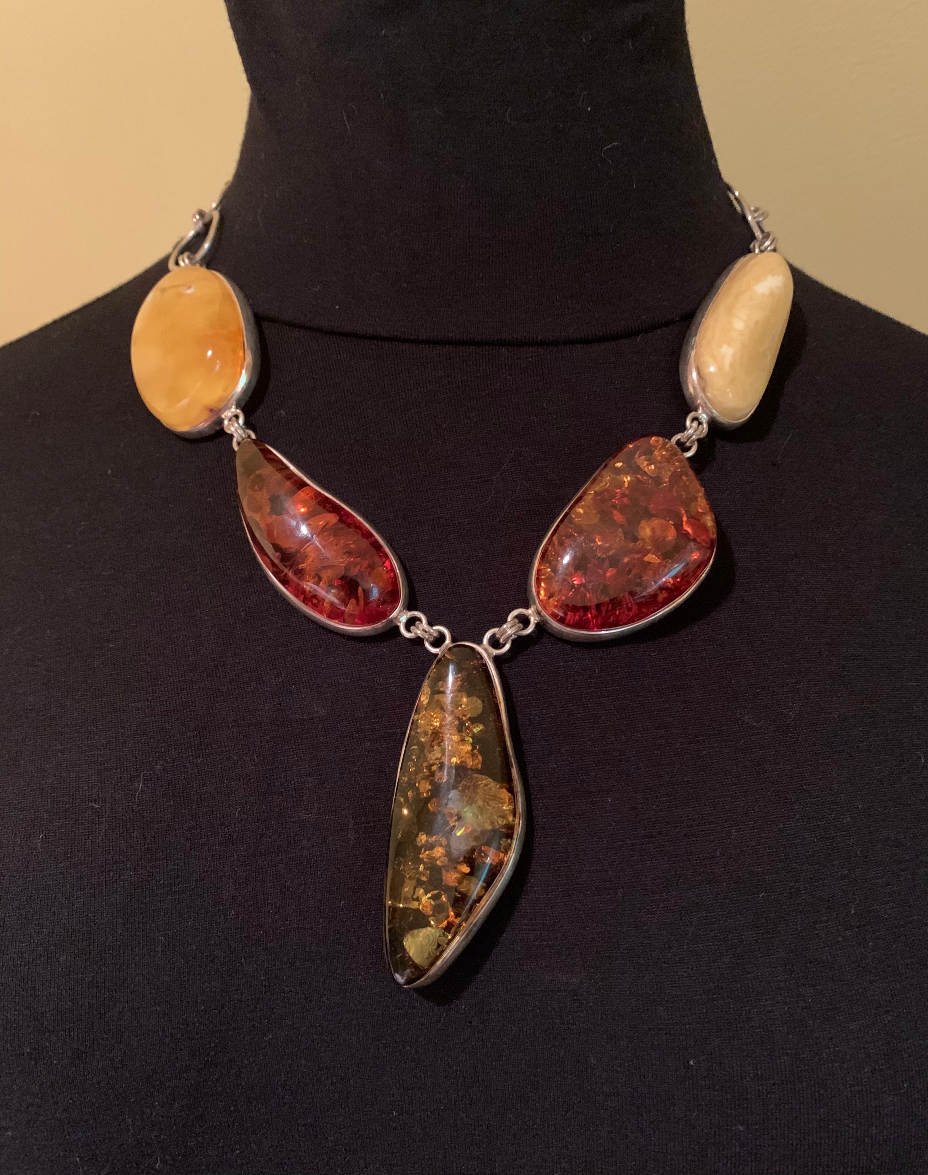 Spettacolare collana in ambra naturale e argento sterling di stile scandi-modernista, composta da cinque grandi pezzi di ambra nei toni del giallo burro, del miele e dell'oliva. Il pezzo centrale misura 2,5 pollici di lunghezza. Ognuno di essi si è