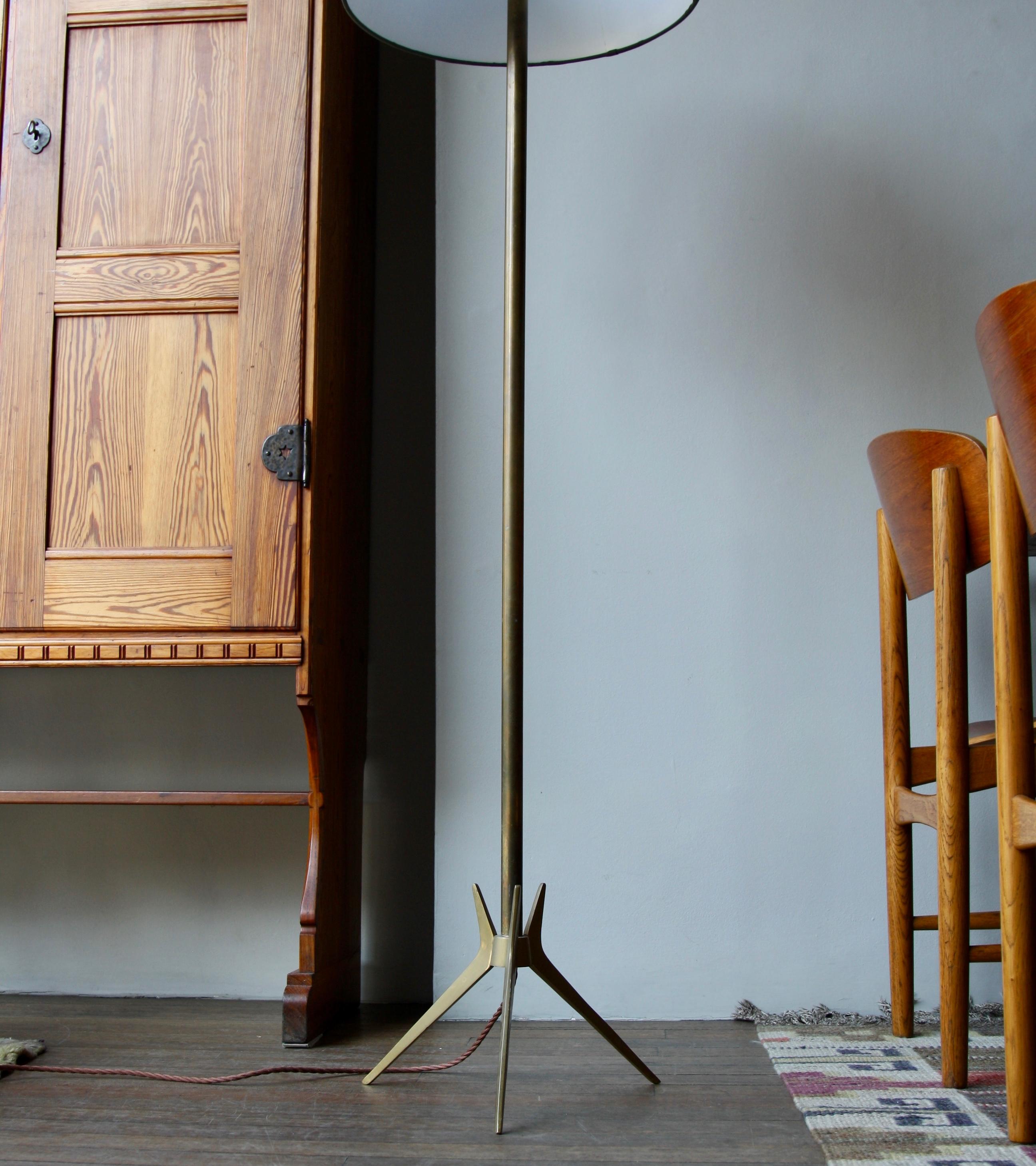 A vintage floor light designed and made in Denmark around 1950. The lamp is made entirely of brass and its form is as simple as its material.
The light is made up of four simple sections; an idiosyncratic 'Crow’s foot' base, a thick central shaft,