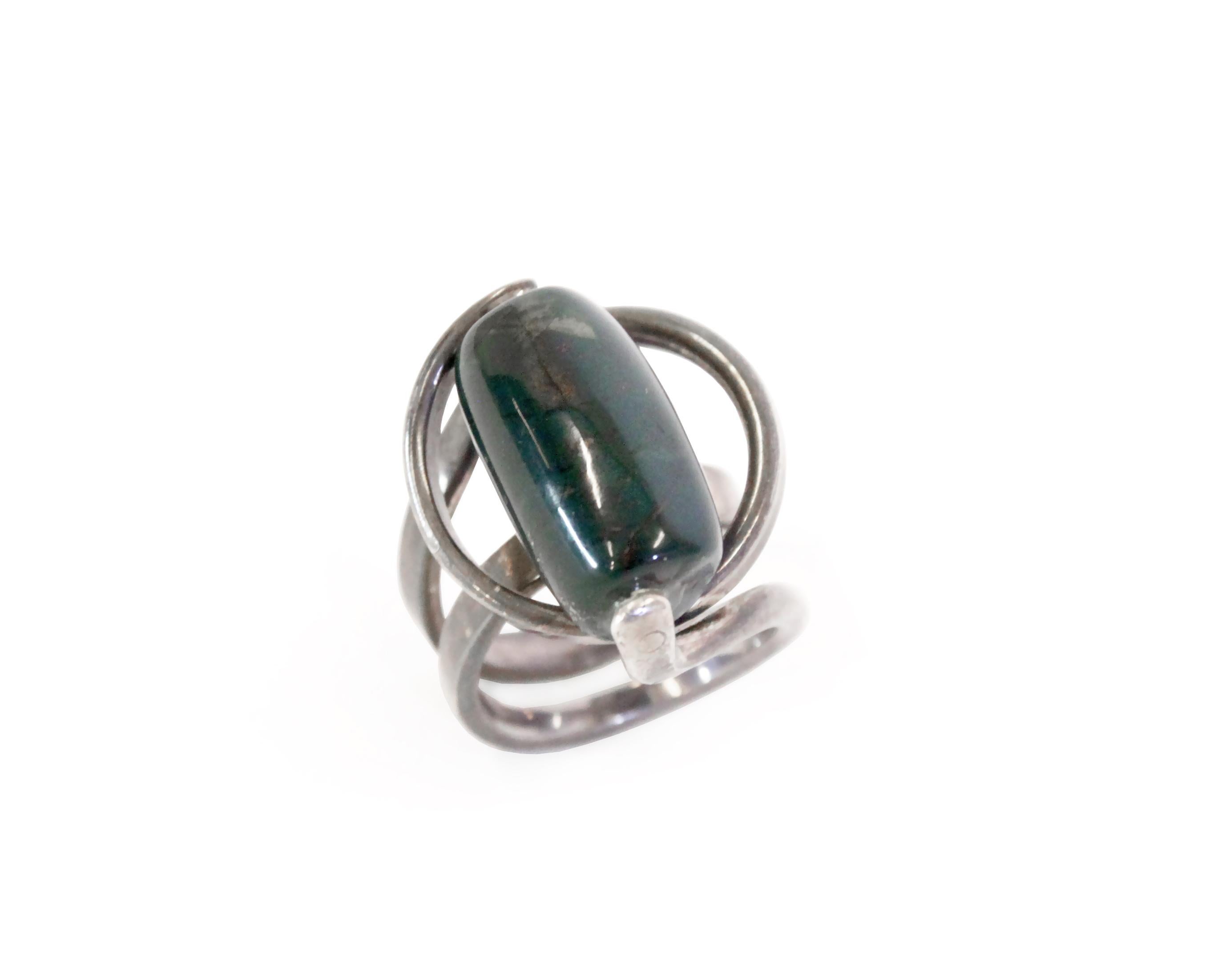 Sculptural and decorative ring in silver with a malachite stone. Designed by Erling Christoffersen and made in Norway by PLUS from ca 1960s second half. The ring is in very good condition with all elements in full working order.

Ring size 57. 