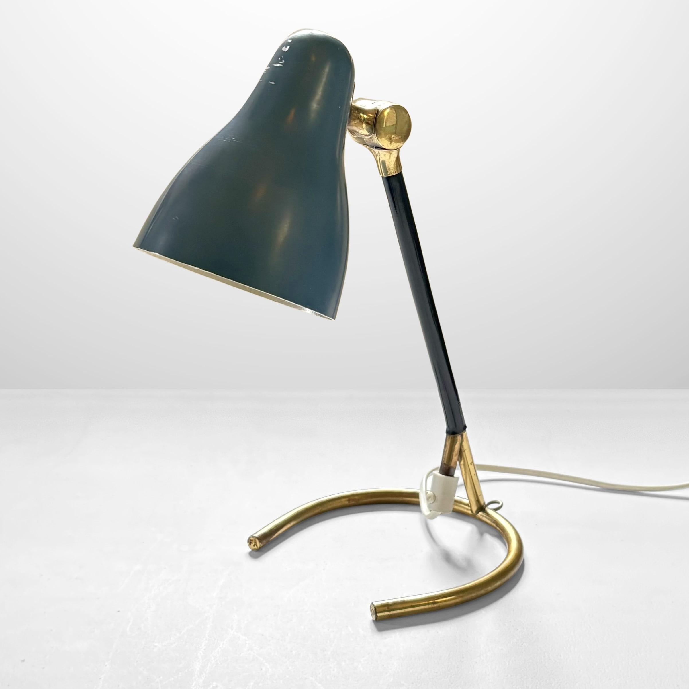A sculptural 1950s table lamp, also mountable on the wall, crafted from solid brass with a painted metal shade that can be positioned in different directions. It features a distinctive horseshoe base and a brass rod partially covered in black