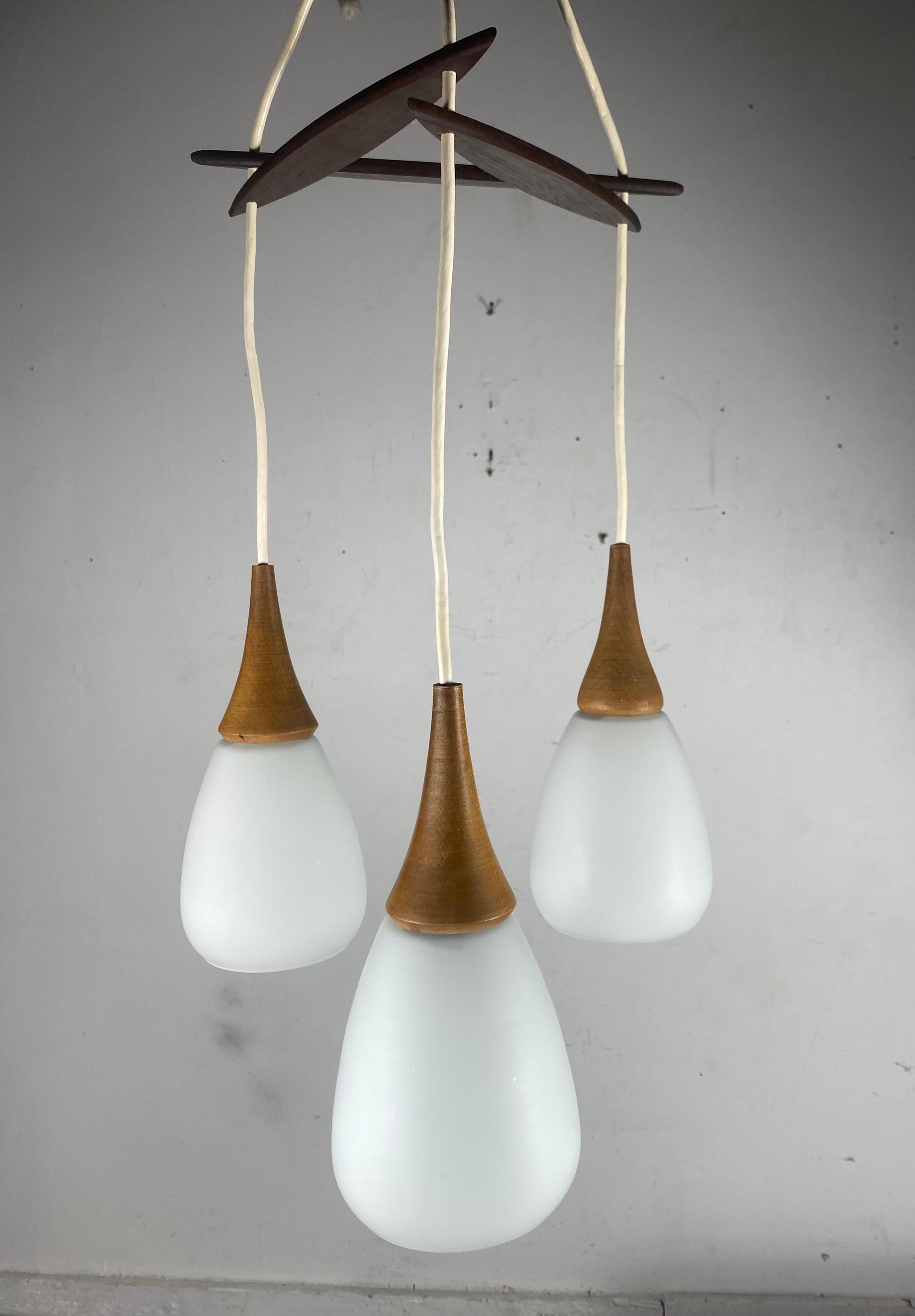 Mid-20th Century Scandinavian Modernist Triple Pendant Lighting.. Teak and Glass.. Holmgaard