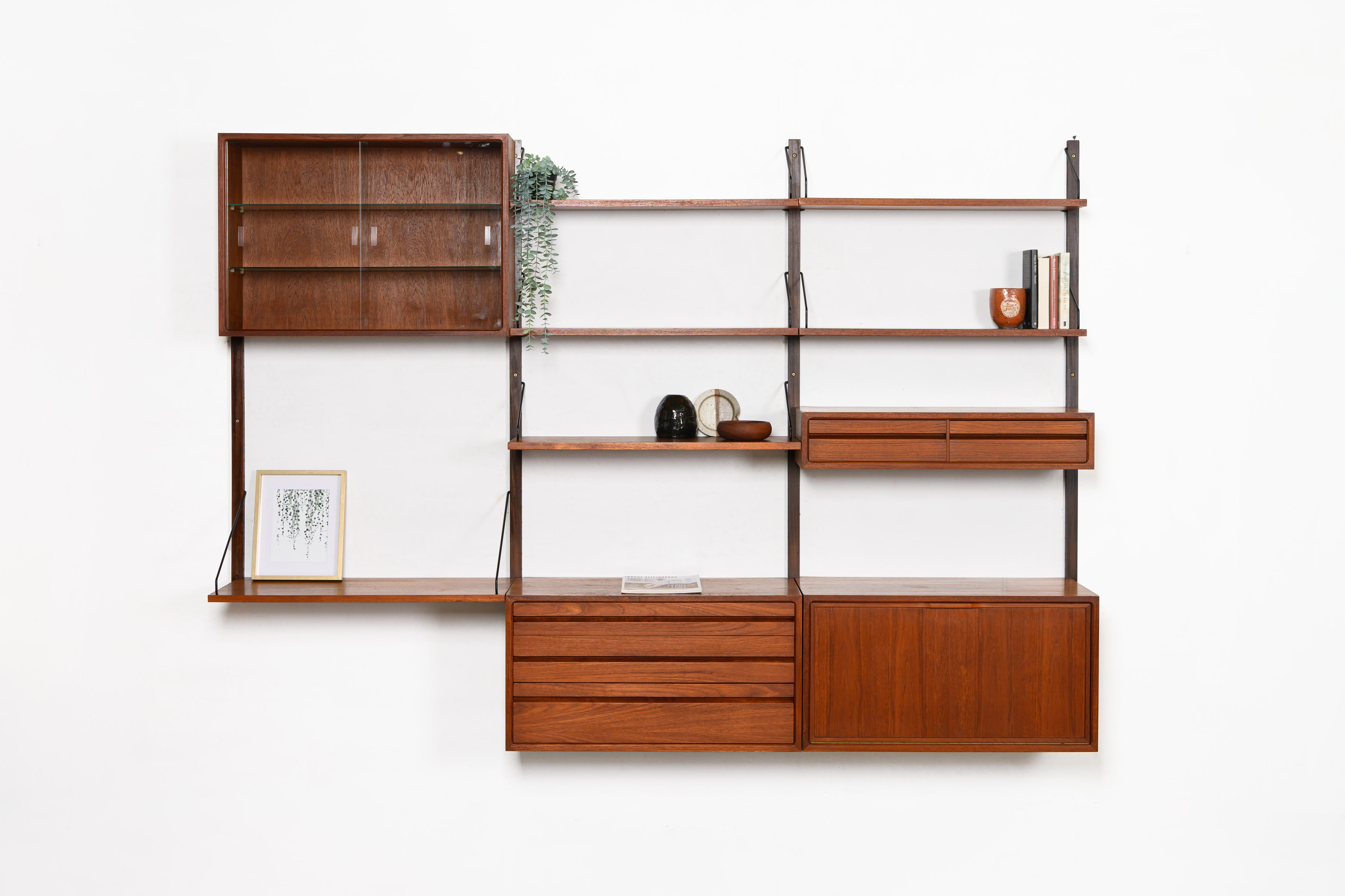 Danish modular wall unit by Poul Cadovius for Royal System. This teak setup has two storage cabinets, one display cabinet, one small drawers cabinet, one desk shelf and five bookshelves. Always adaptable and further expandable.

Dimensions:
W: 244