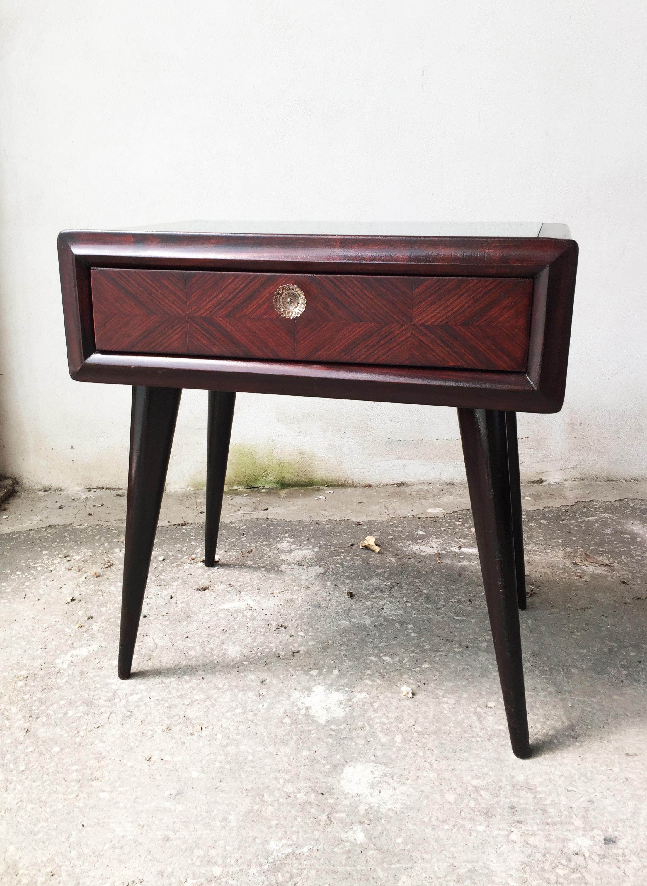 Beautiful nightstand in mahogany, rosewood and clear glass on top.
There is also one drawer with a beautiful glass handle and amazing veneer on the frontal side.
Four conical legs completed the beauty of this piece.