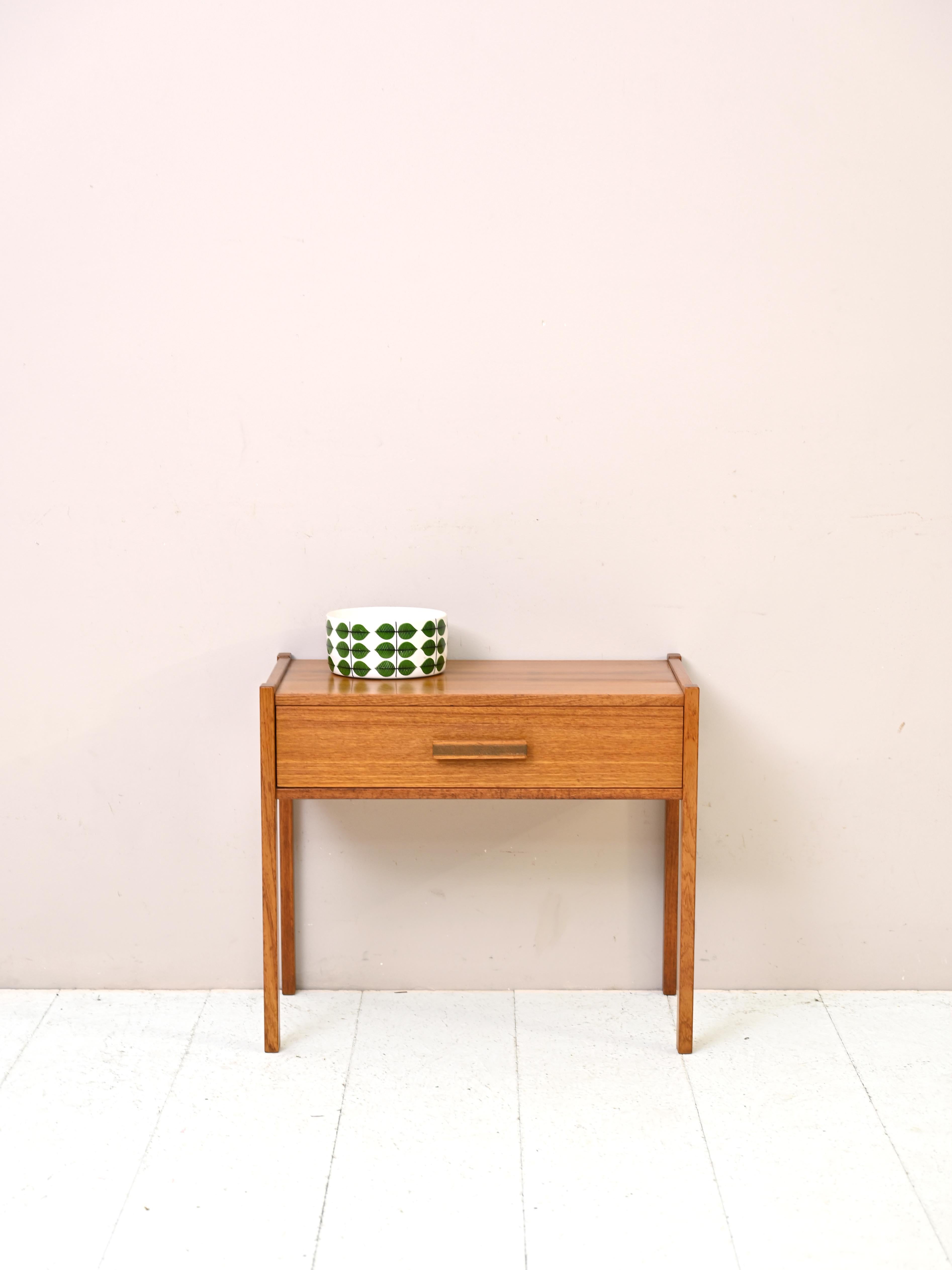 Table basse vintage en teck des années 1960.
Un meuble unique qui reflète le design élégant et fonctionnel des années 1960. Cette table d'appoint en teck est dotée de pieds carrés fins et d'une poignée en bois caractéristique. Adaptée à toutes les
