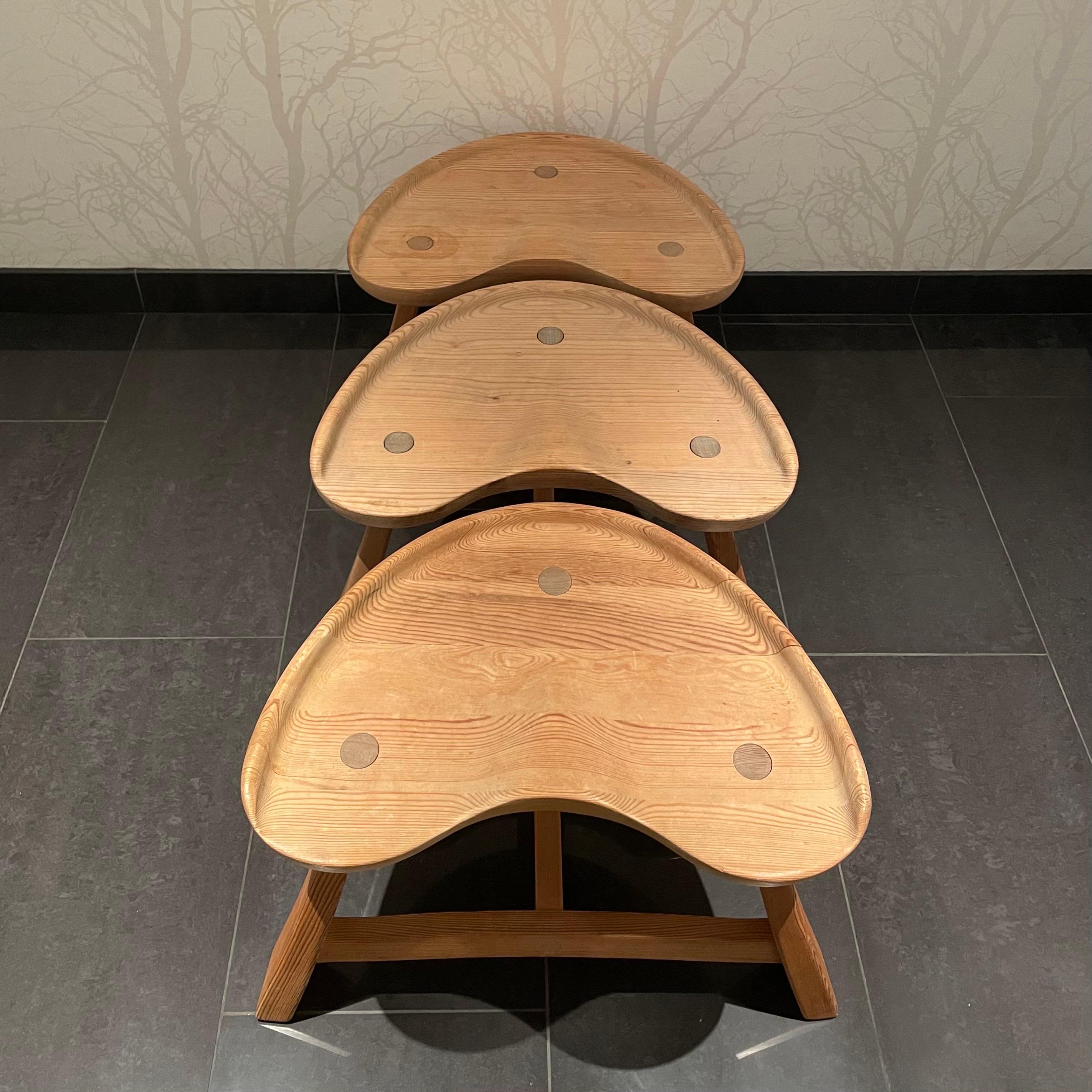 This is the Norwegian Krogenæs Möbler’s solid pine stool set of three, model nr 522.
It comes in a stable, three legged construction with patinated untreated surface. Two of the three stools are burn marked “Krogenæs Möbler” on the underside of the