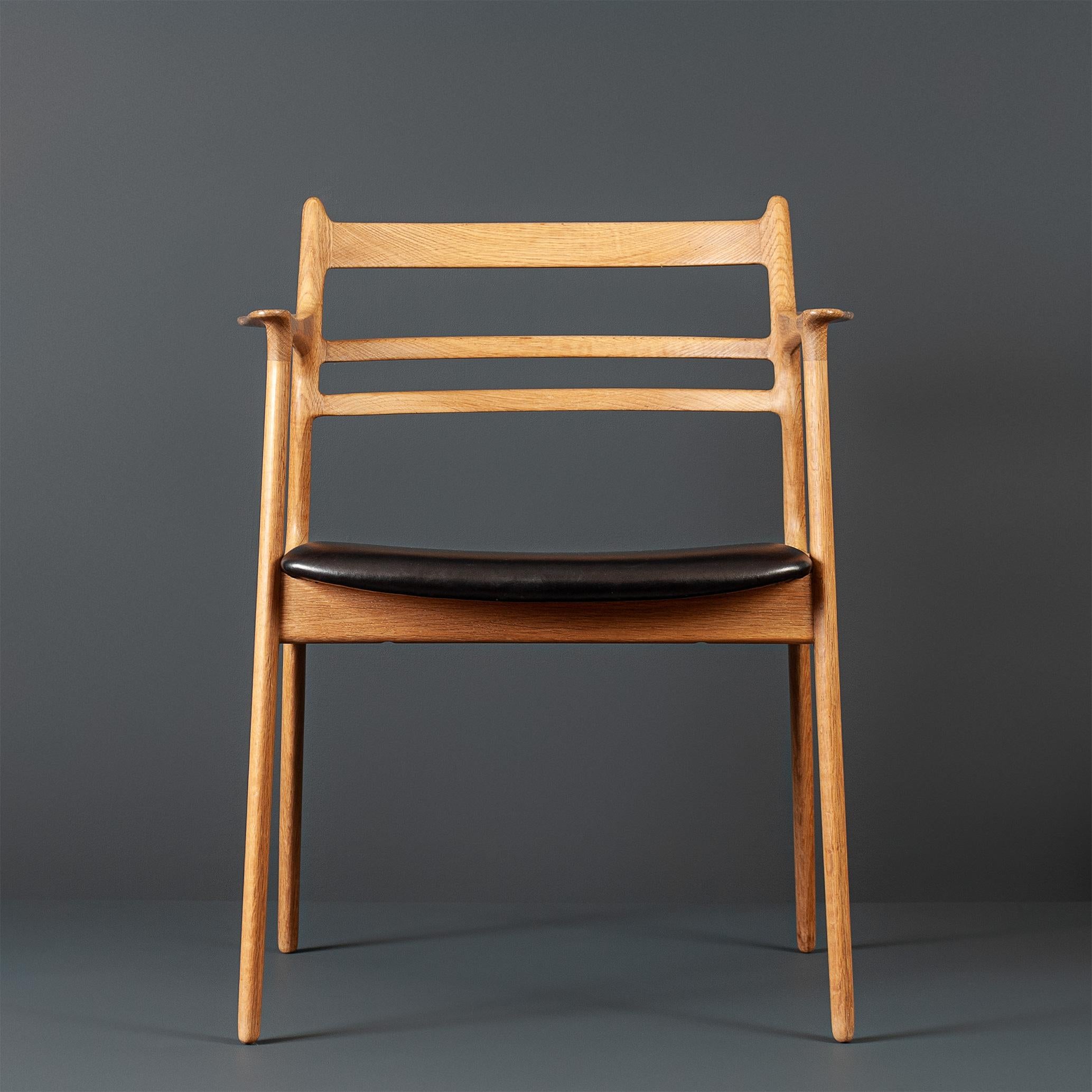 A remarkable and unique oak and leather chair. Striking curved and slick streamlined frame with a design aesthetic straight from the Moller book. The oak frame has been thoroughly cleaned and re-soaped as per the original and traditional method. The