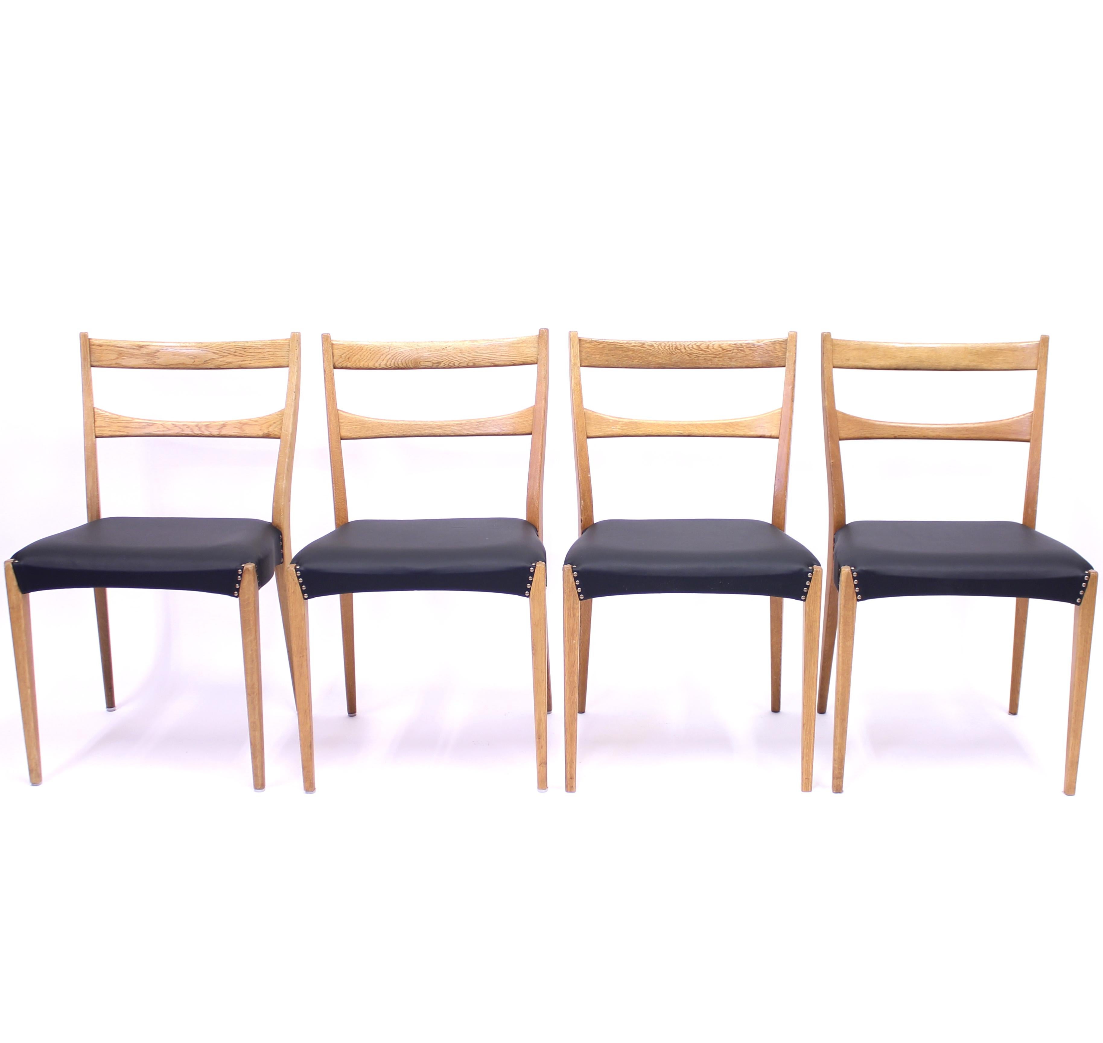 Scandinavian oak dining chairs in the style of Josef Frank for Svenskt Tenn, most likely Swedish, from the midcentury with new black leather seats. Light in appearance due to the nicely designed neat frame. Good vintage condition with light ware on