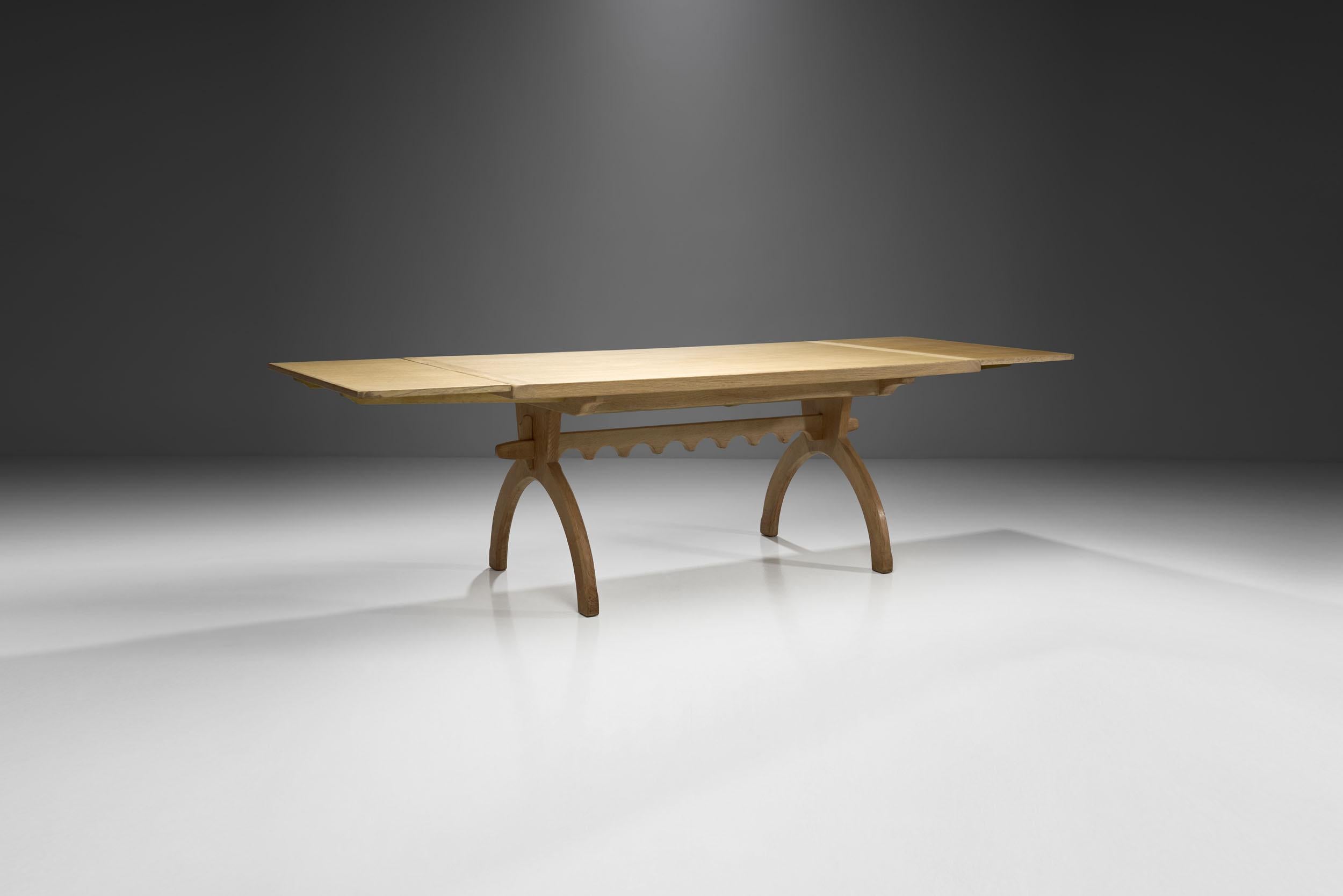 This impressive Scandinavian table is defined by its natural material, seamless joinery and distinctive, but soft ornamentation on the bottom. 

Albeit the table is made of solid wood, the oak’s light color and the slender lines create an airy