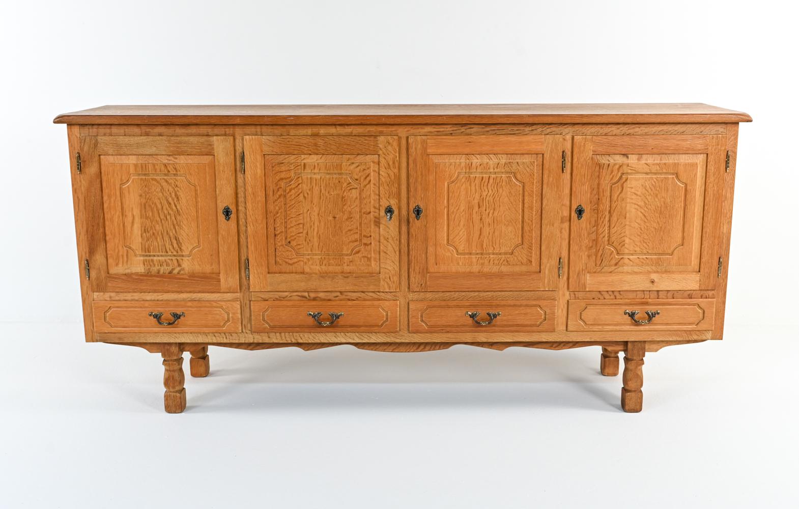 Quarter-sawn tiger oak takes center stage in this fabulous sideboard cabinet, which features raised-panel millwork doors, sculpted legs and an unusual notched apron. Four felt-lined drawers and four large cabinets with adjustable shelves provide