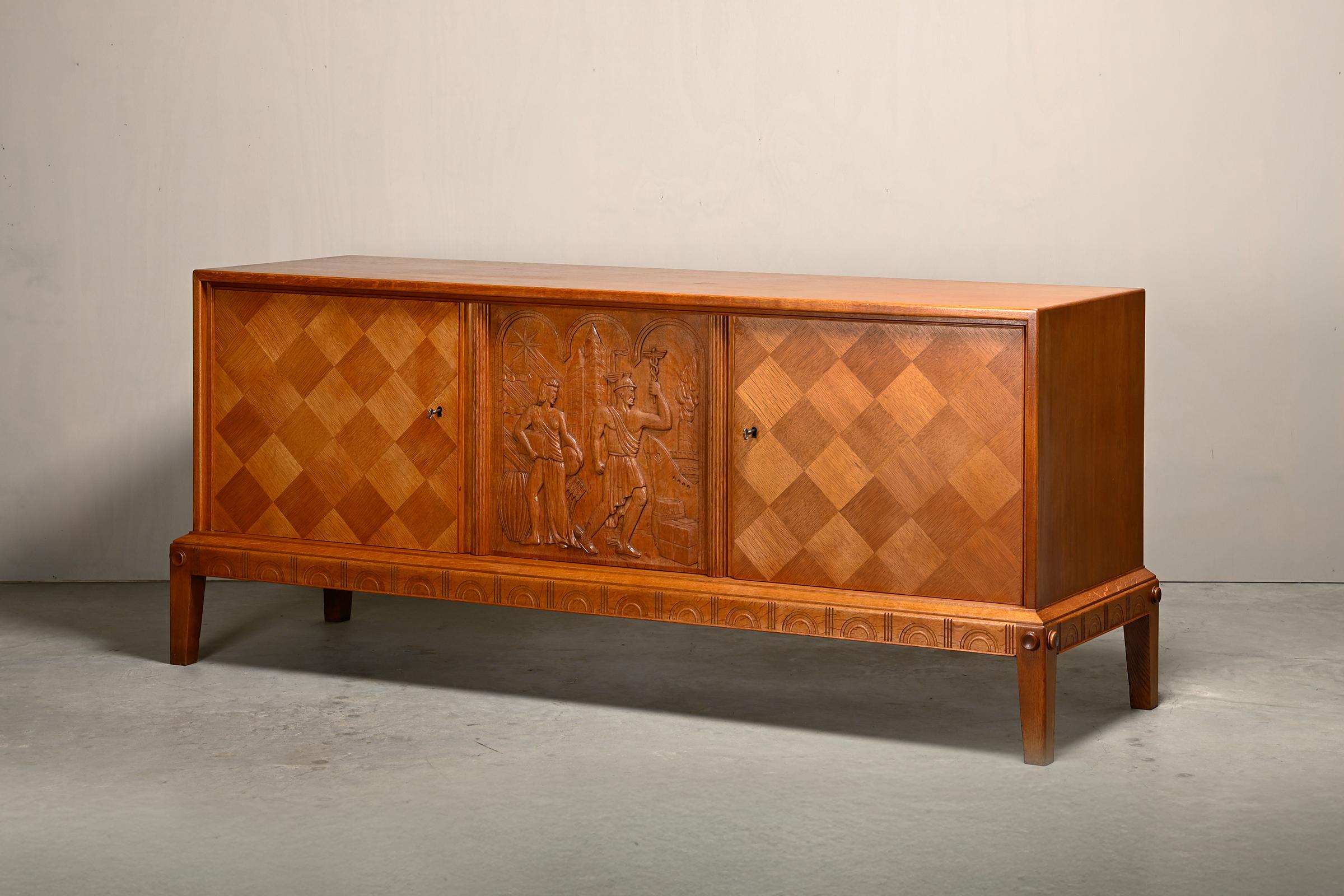 Elegante credenza scandinava in rovere di un designer/produttore sconosciuto, Svezia anni '60. Una base decorata con medaglioni e semicerchi intagliati. Sopra c'è uno spazio per riporre due ripiani dietro due ante con impiallacciatura a rombi. Tra