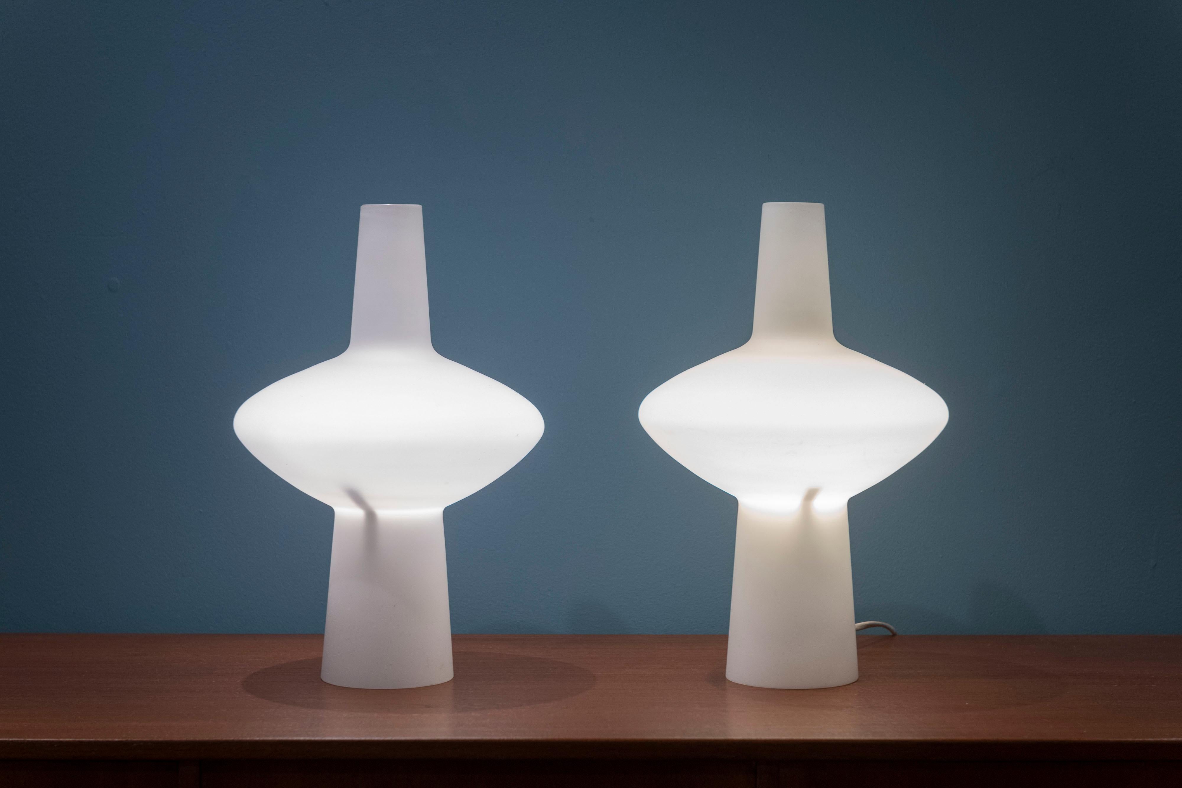 Scandinavian Modern opaque glass table lamps, Sweden. Sculptural form lamps that emit a lovely and soft glow, in very good original condition. One labeled Buhlmarks, Sweden.