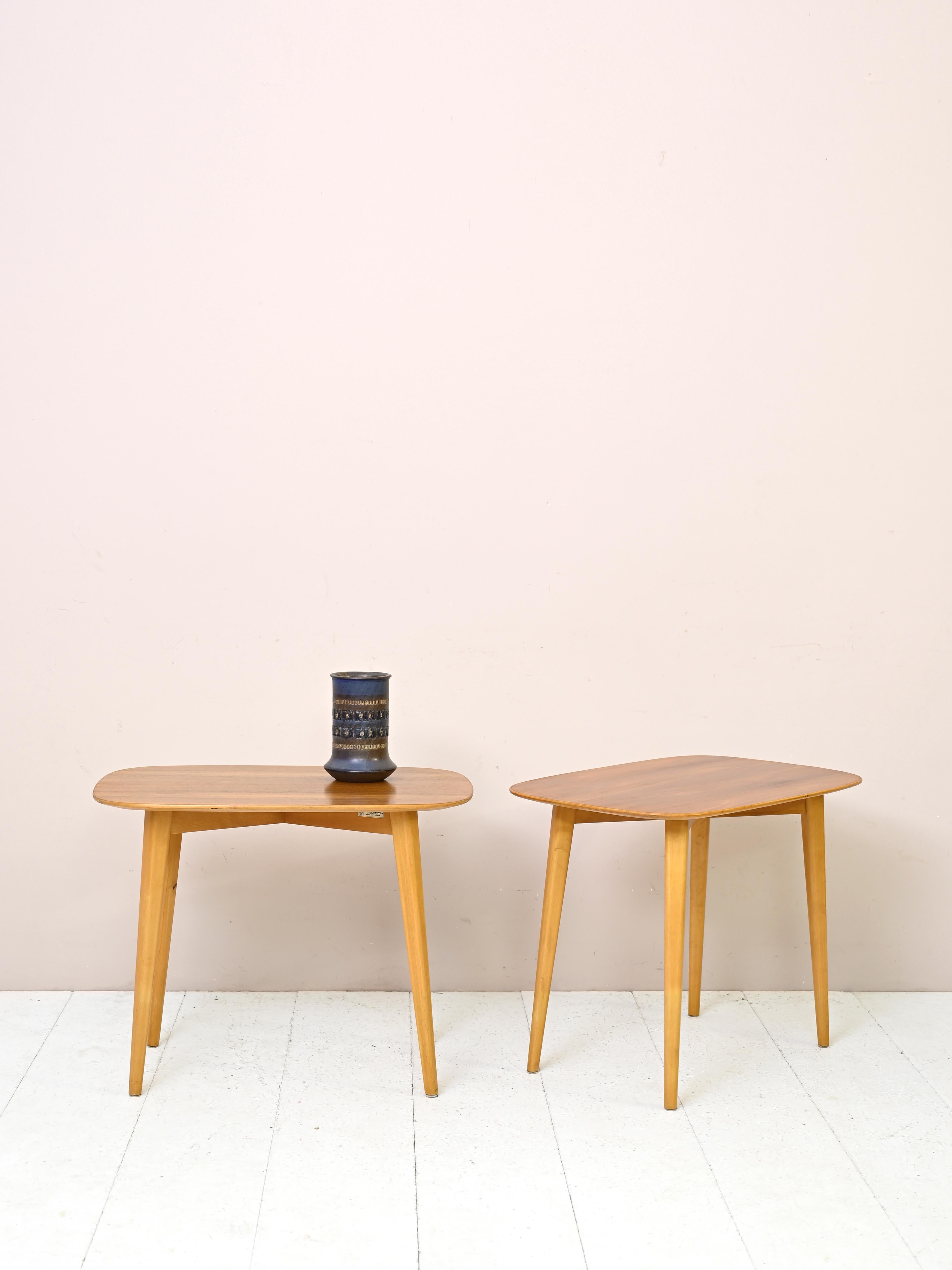 Pair of vintage wooden side tables.

These sofa tables feature a simple top with rounded corners and an exposed X-shaped frame from which tapered legs depart.
The elegant and minimal lines make them suitable for placement in already furnished