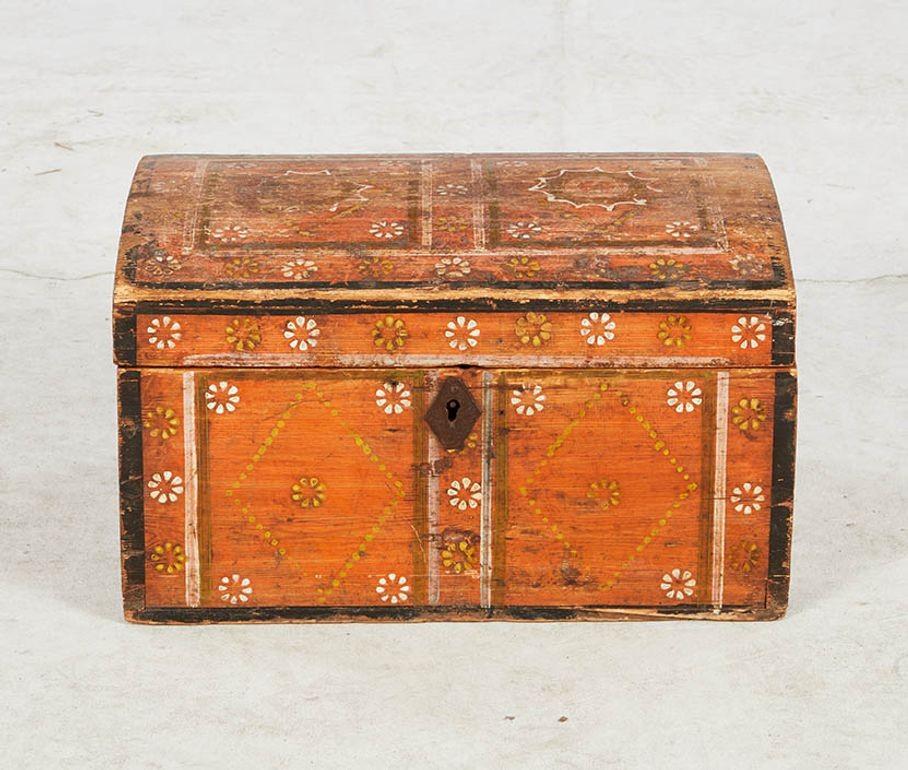 Caja escandinava de principios del siglo XIX, pintada al estilo popular, con tapa abovedada, toda ella con fondo de color calabaza y decoración floral, toda en pintura original.