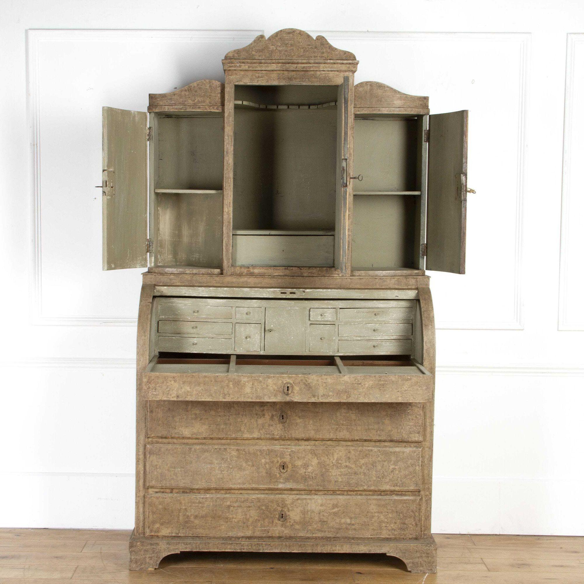 A lovely painted roll top desk with cupboards to the top and a bow front central door.
Under the roll top is a pull out section with sliding panels for storage.
It has sprung locks with keys.
A rare piece to adorn your home.
