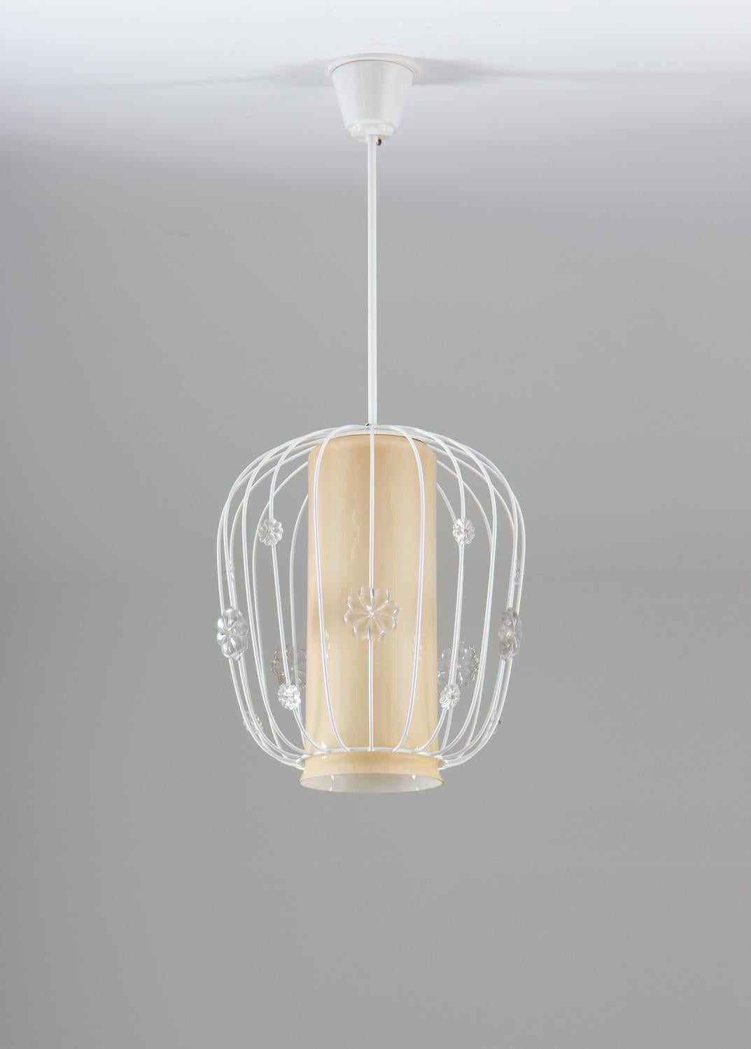 Rare and elegant pendant in metal and glass, produced by Böhlmarks, Sweden.

The lamp features one light source behind the opaline glass shade, giving a beautiful and soft light. The shade is surrounded by a metal shade, decorated with clear glass