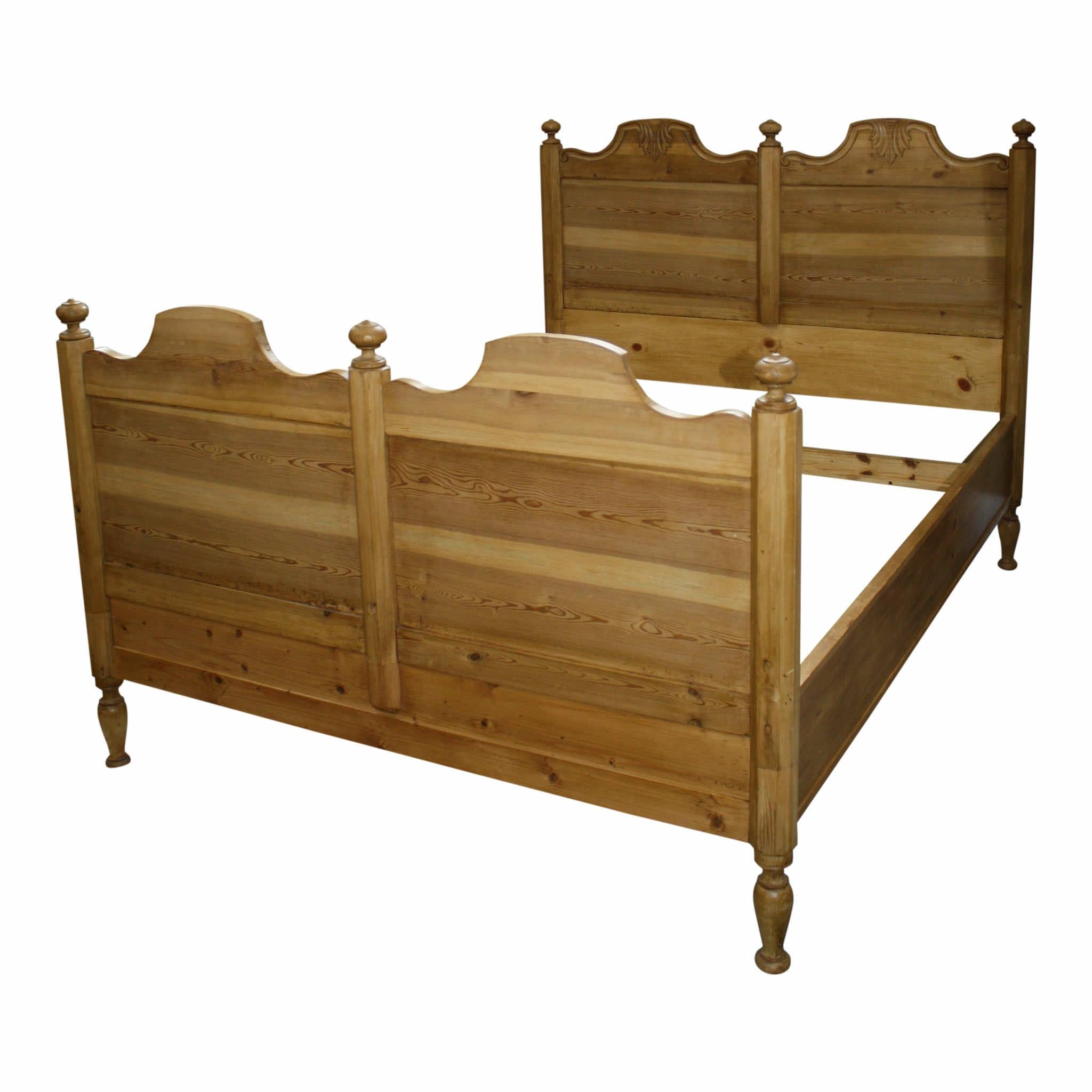 Crafted in Scandinavia, this bed frame incorporates the warmth and beauty of carved pine with the dramatic, clean lines of scooped corners on the headboard and footboard. Turned finials accent the center and outside posts. The frame is raised on