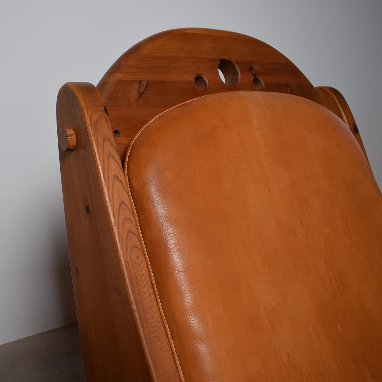 A Scandinavian pine rocking chair from the late 70s

This comfortable chair features a solid, pine wooden frame with a seat and backrest in cognac leather. Organic, rounded shapes with an ergonomic design. 

