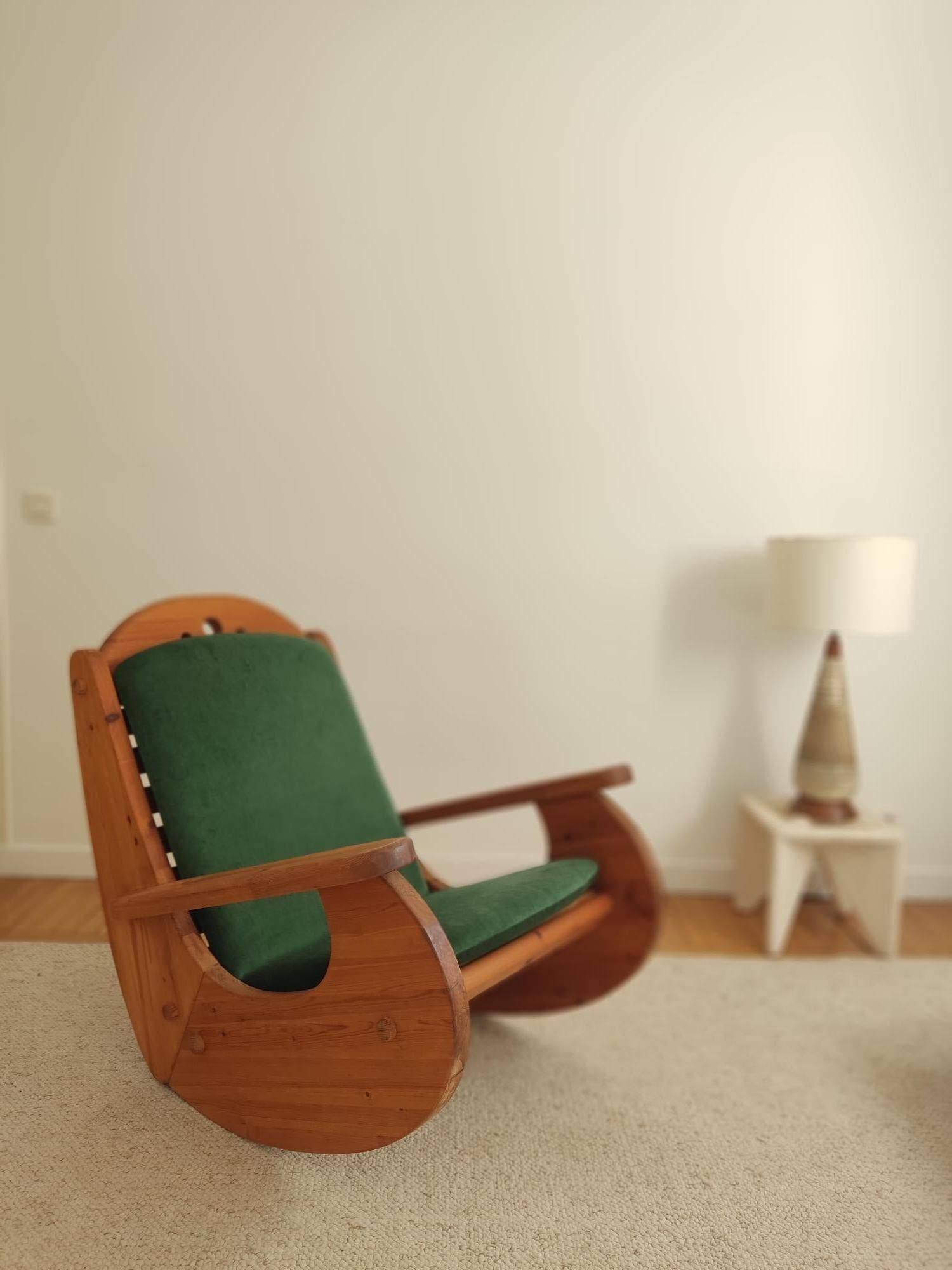 Scandinavian rocking chair from the 1970s in pine wood. The assembly is doweled with wood. The warm colors and rounded shapes will give a cocooning atmosphere to your interior. New green mohair velvet cushion.



