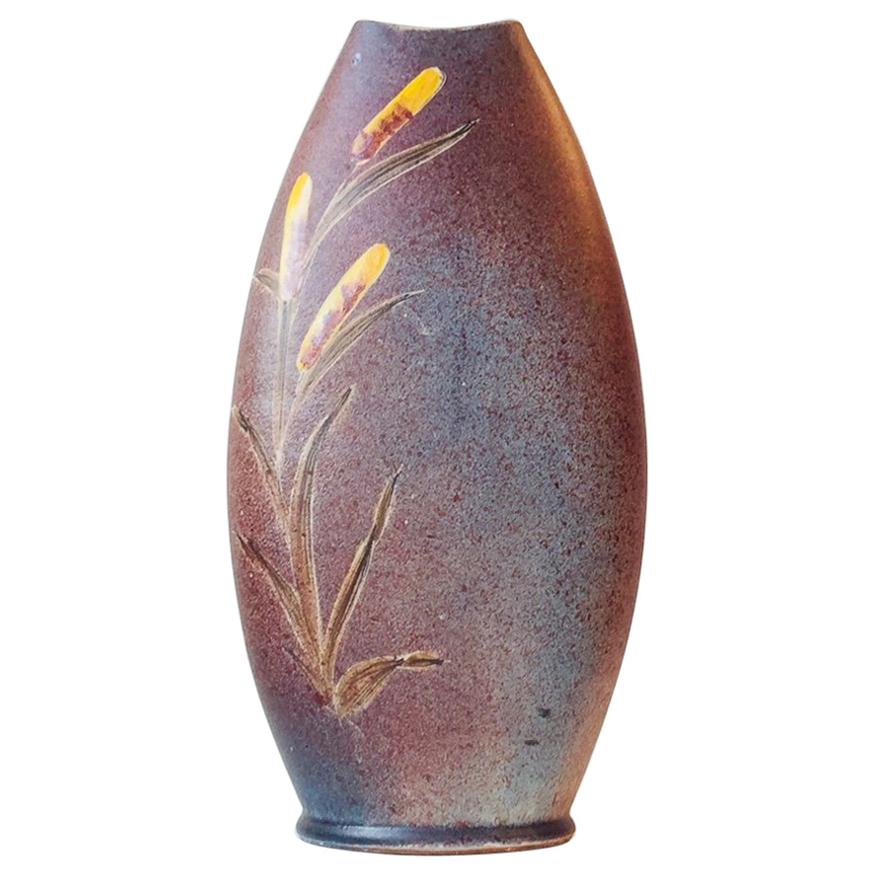 Vase de sol délicatement émaillé en bleu poussiéreux, rose et violet et glaçures appliquées à la main représentant des canards d'un côté et des 'Bulrush' de l'autre. Il est signé Tilgmans, en Suède. La décoration de la glaçure est de C (non