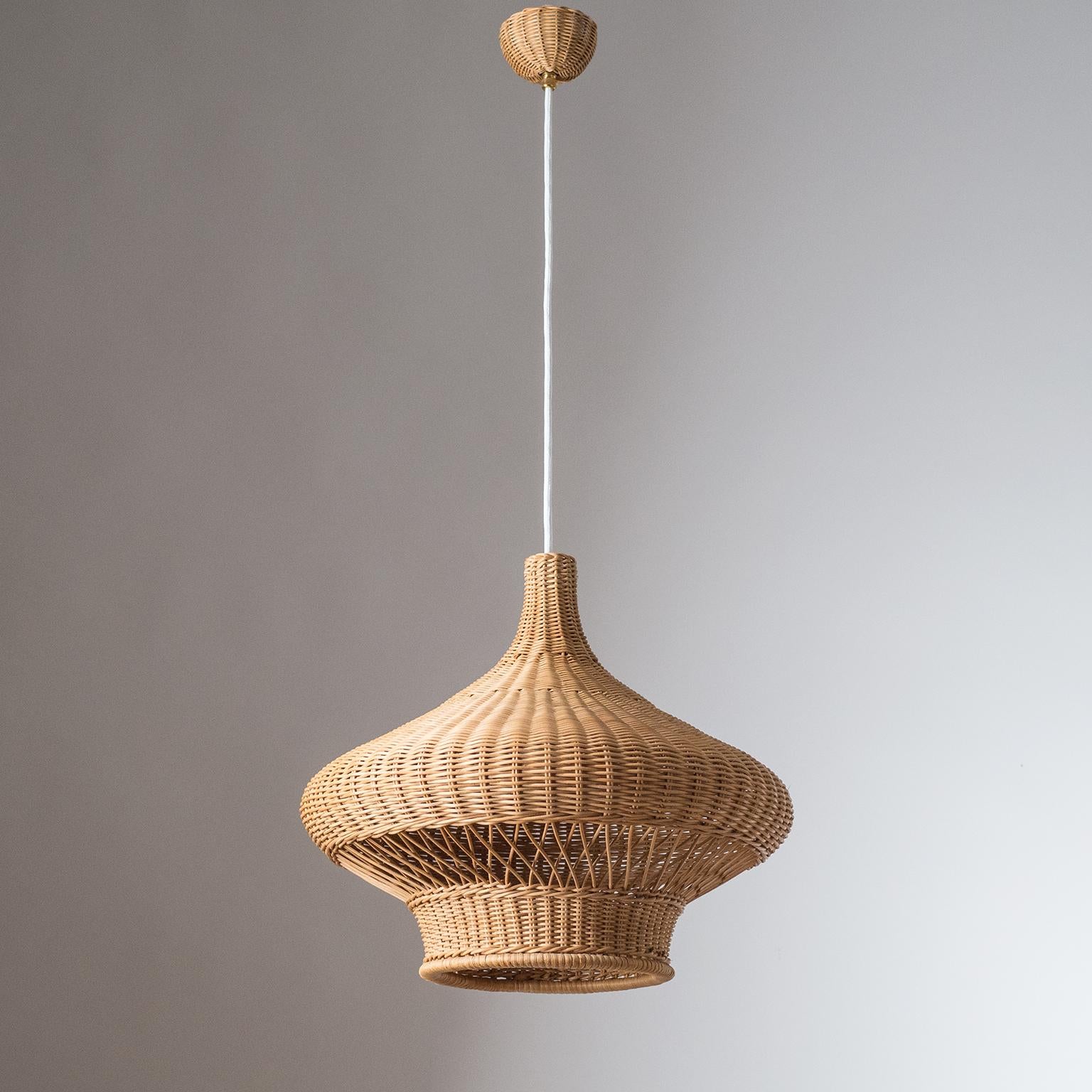 Rare intricately woven rattan or wicker pendant from the 1960s. One original E27 socket with new fabric wiring. Height of the body circa 14inches/36cm. Drop height adjustable up to 57inches/145cm.