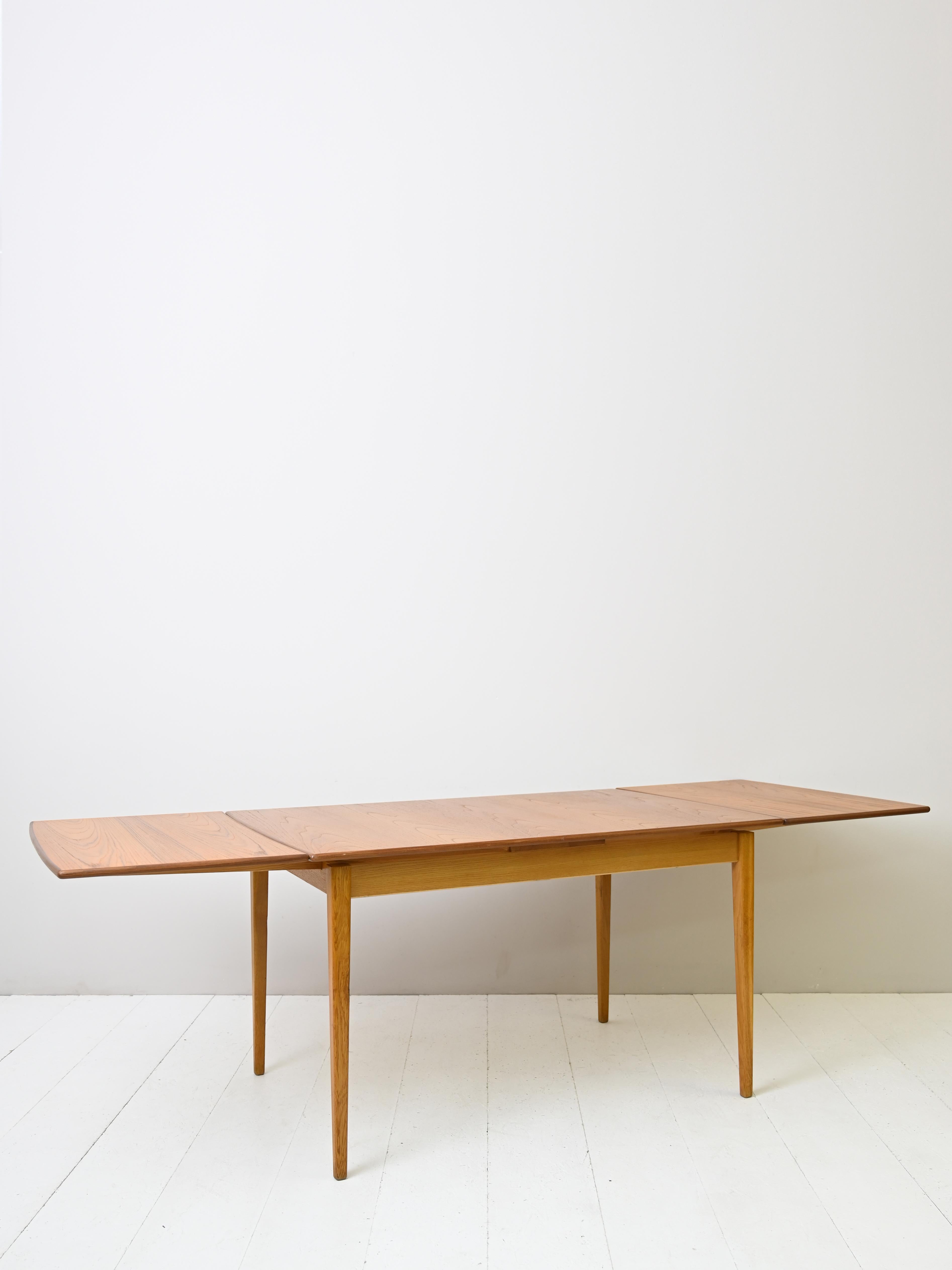 Vintage extendable rectangular table.
Swedish-made dining table with two extendable wings. 
Refined details and elegant lines are the distinguishing features of this original piece of furniture from the 1960s. 
Uncompromising functionality thanks