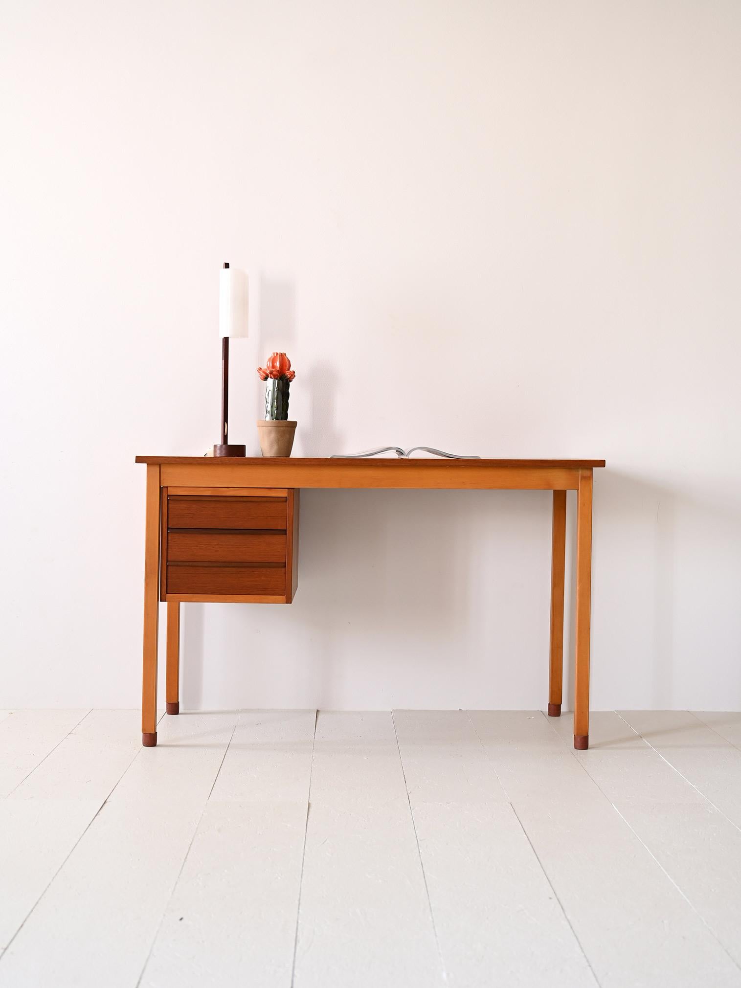 Swedish-made 1960s table with drawers.

This desk with square, minimalist lines features a 125-cm-long rectangular table top under which there are three drawers.  Consisting of a teak frame, it is supported by beech wood legs that create a pleasant
