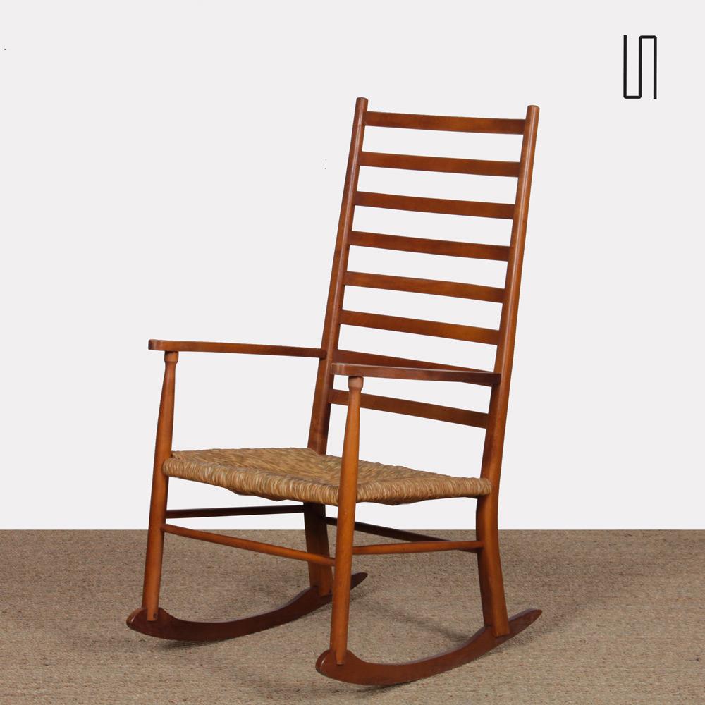 Ce rocking-chair scandinave date des années 1960. Le cadre est en bois et le siège en paille. Ce fauteuil est en bon état d'origine.
