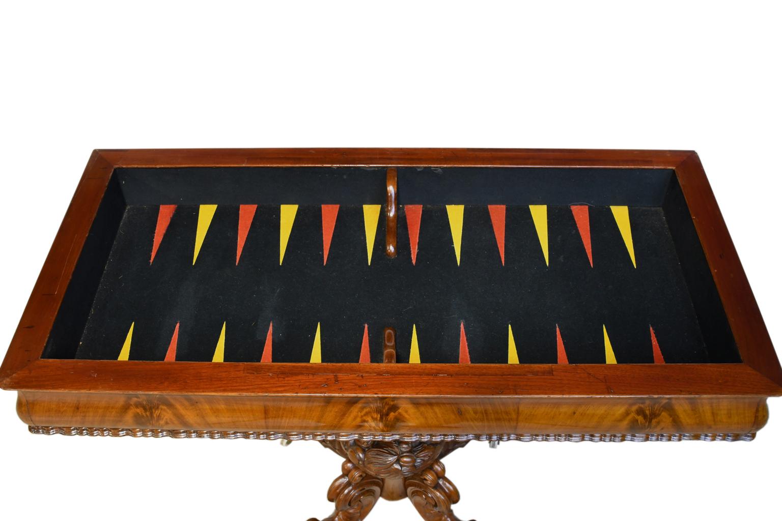 Rococo-revival game table in Cuban mahogany with beautifully-articulated pedestal base, backgammon felt-lined inner playing surface and two round surfaces that pullout / pull-out for drinks. Top lifts & opens to a square on a fully-finished base