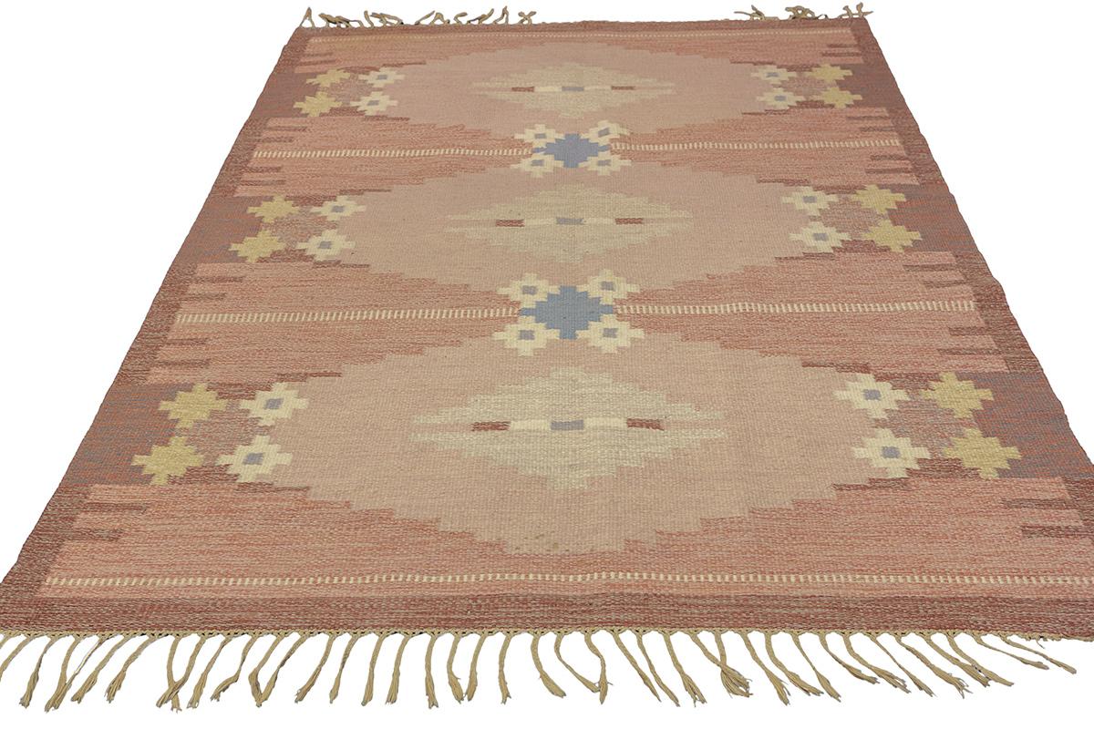 Entrez dans le monde calme du design scandinave avec ce tapis scandinave serein Rollakan, une expression artistique de l'élégance tranquille et de l'artisanat durable. Sa palette neutre et apaisante de beiges doux, rehaussée de bleus et de jaunes